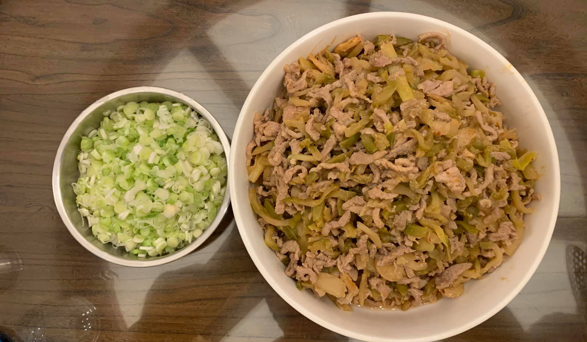 炒好的榨菜肉絲及蔥花上桌。
