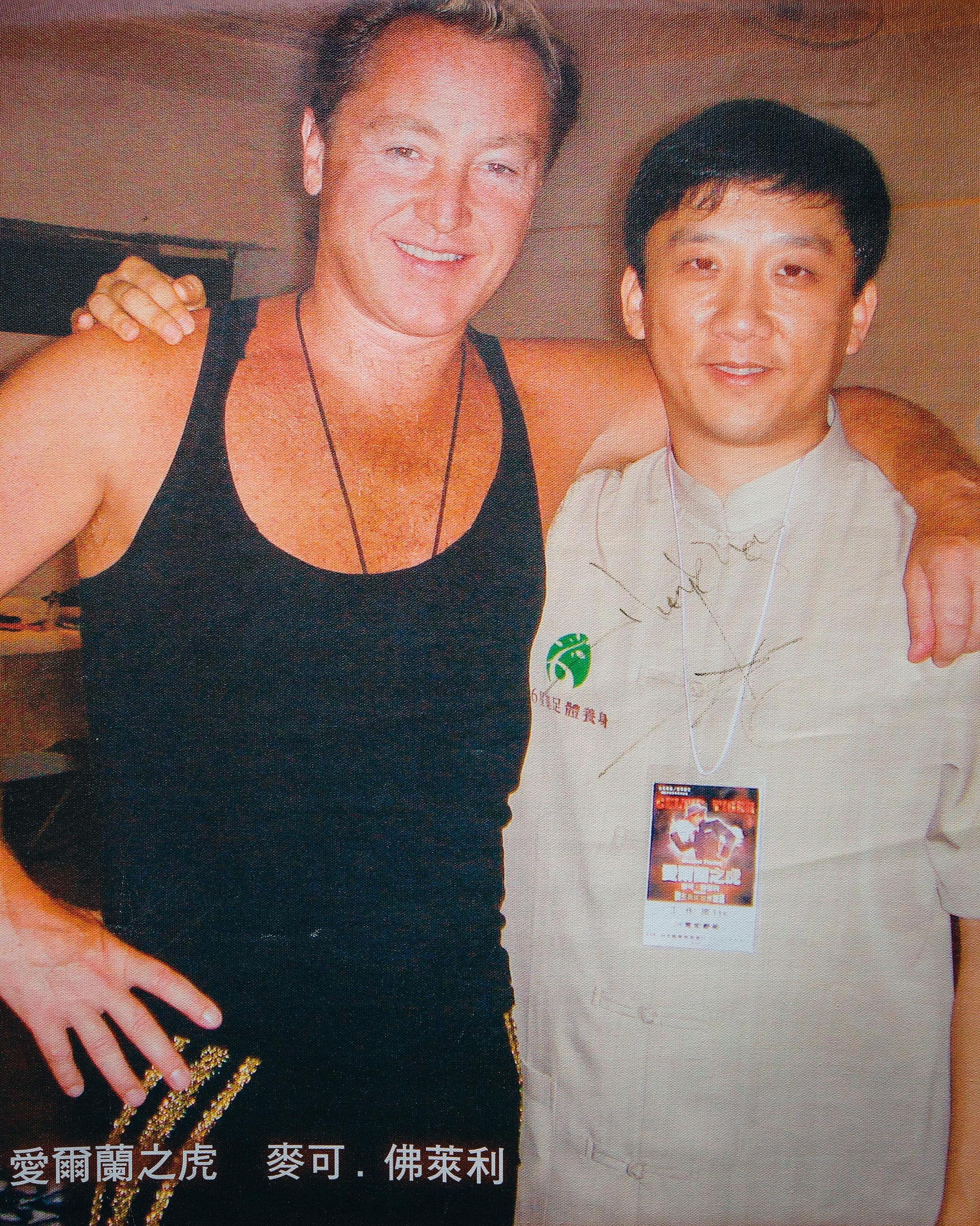 江慶鐘（右）辦公室牆上，貼著愛爾蘭踢踏舞王麥可‧佛萊利的合照海報。當年他親自帶師傅進到後台替舞王服務。