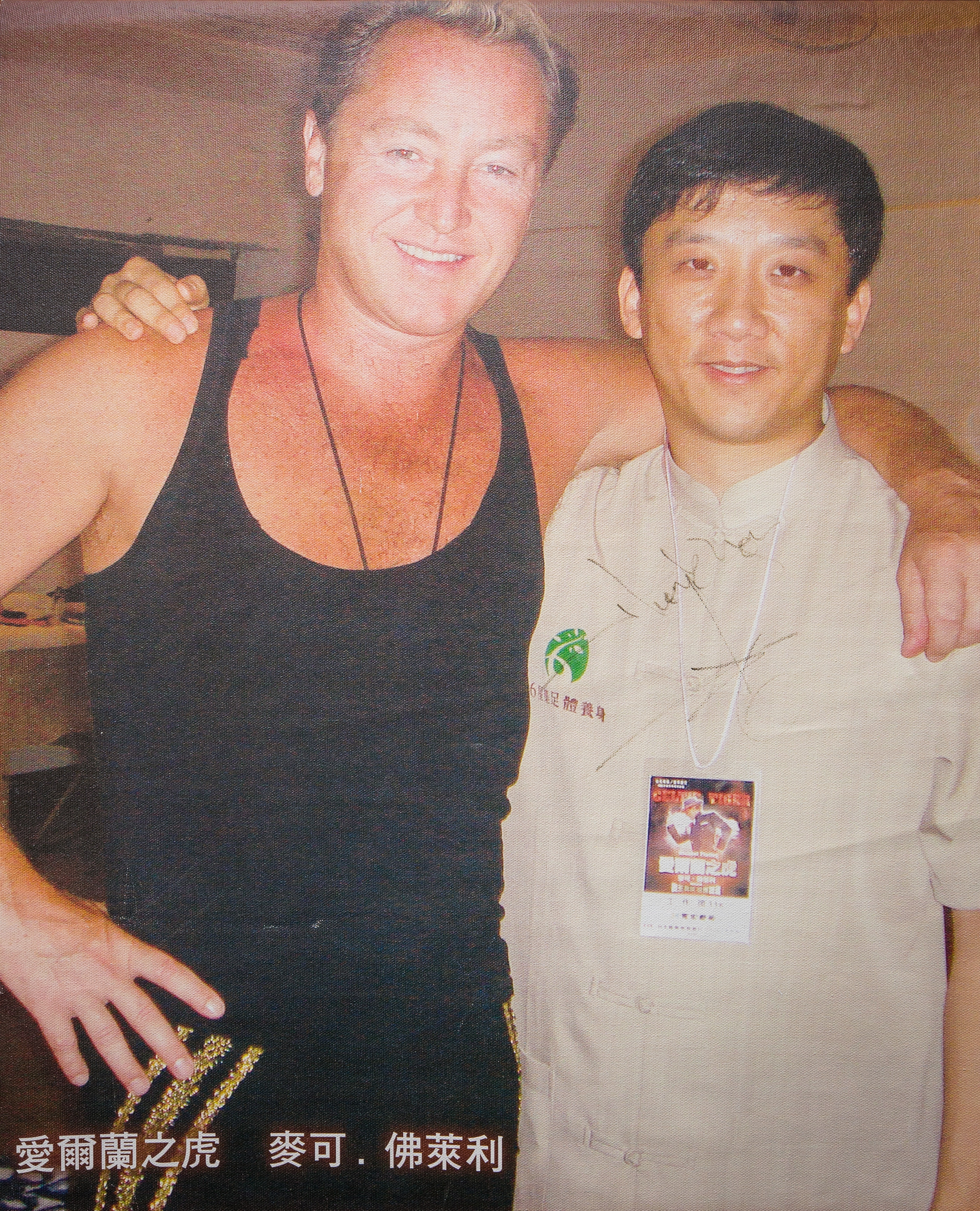 江慶鐘（右）辦公室牆上，貼著他與愛爾蘭踢踏舞王麥可‧佛萊利（左）的合照海報。當年他親自帶師傅進到後台替舞王服務。