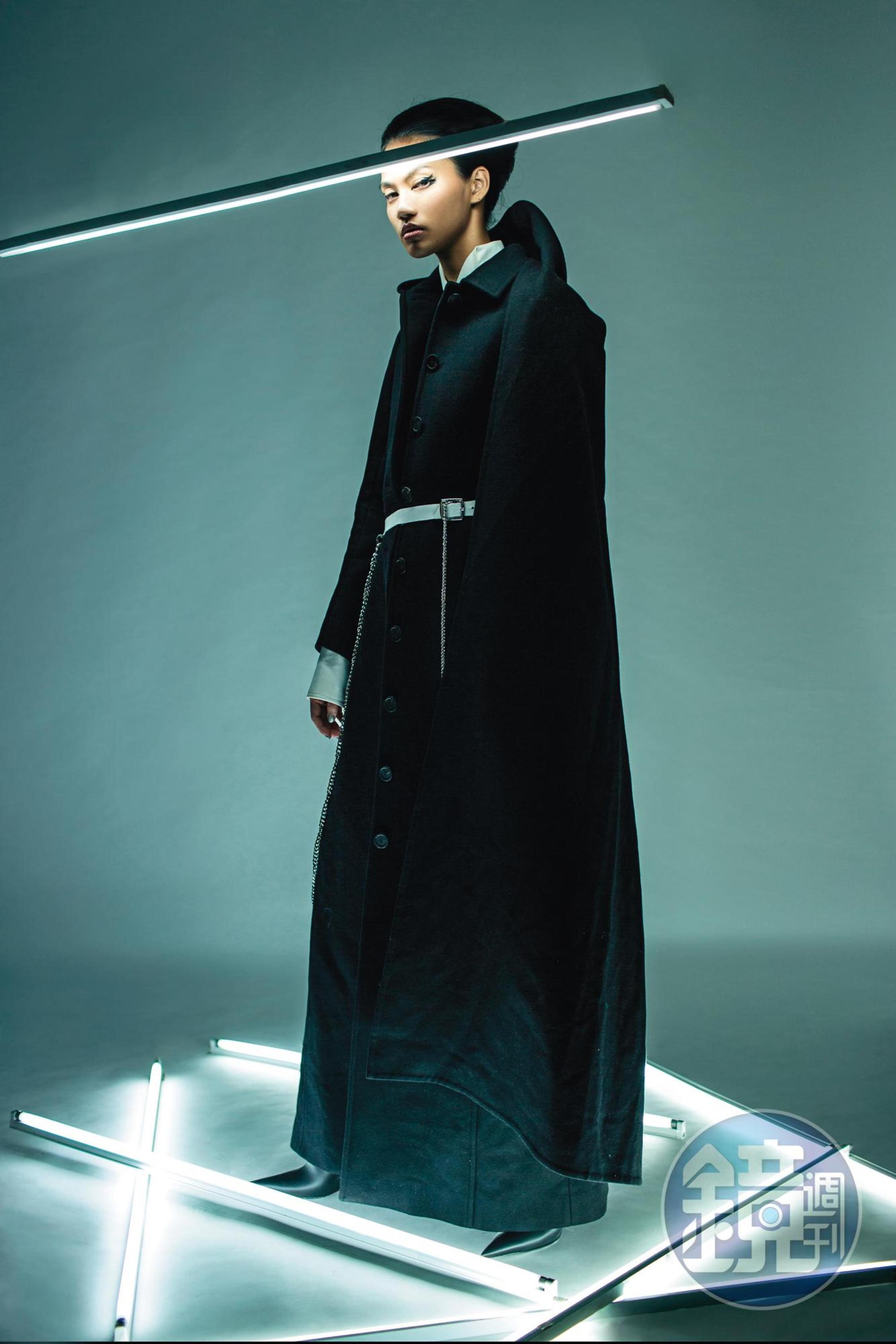 黑色連帽大衣 NT$233,400 by BALENCIAGA／2件式 洋裝NT$88,000 by LOEWE／黑色尖頭靴 價格店洽 by BALENCIAGA／白色鍊條腰帶 NT$4,580 by Phoenix Yang。