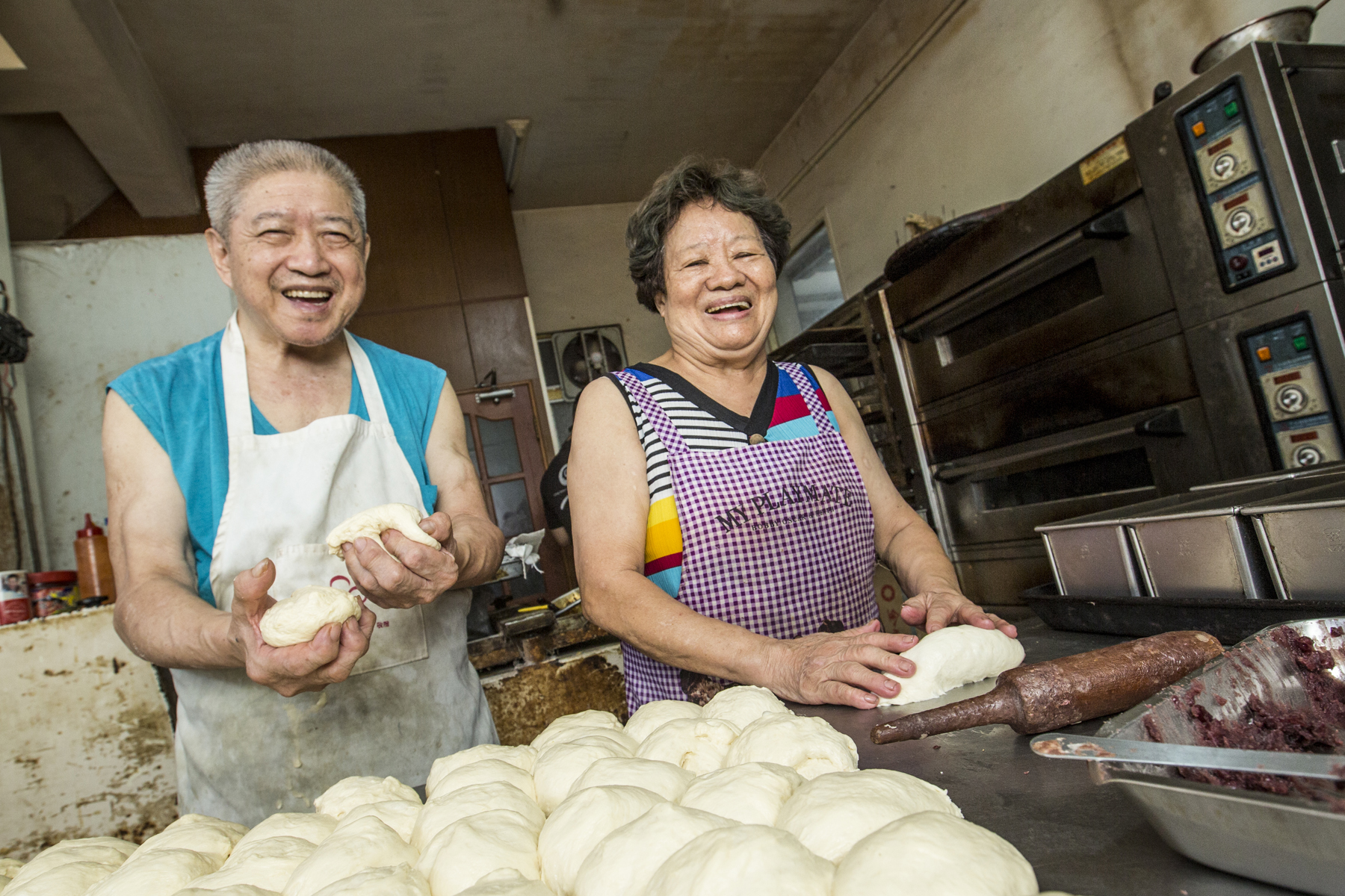 超過70歲的鄭正宗（左）與陳素英（右）做麵包30多年，靠著火盛製餅舖賣餅、麵包，拉拔孩子長大。