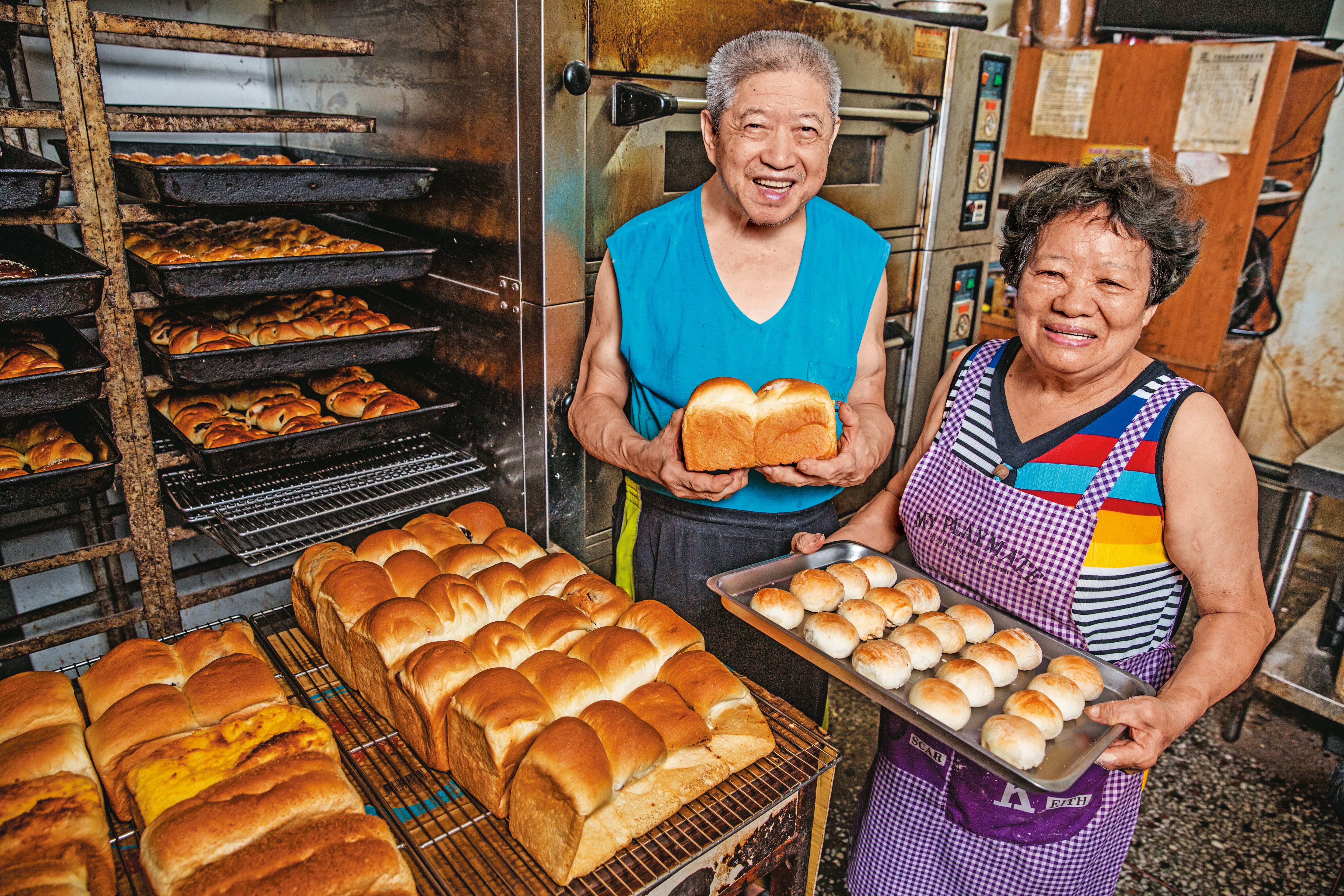 超過70歲的鄭正宗（左）與陳素英（右）做麵包30多年，靠著火盛製餅舖賣餅、麵包，拉拔孩子長大。