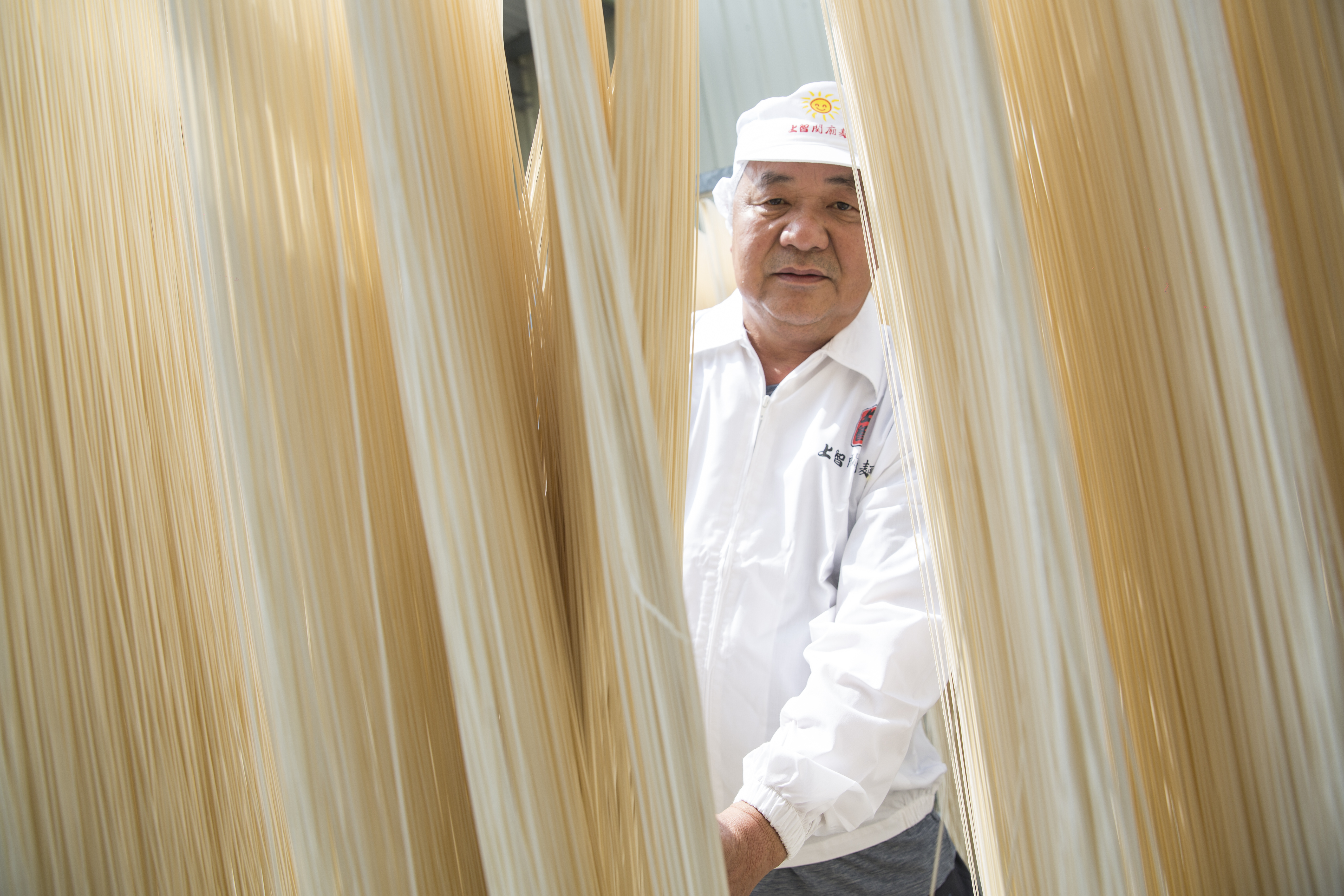 吳金智首創科技化製麵，創新麵條造型，攻進乾拌麵市場，如今產量為業界最大。