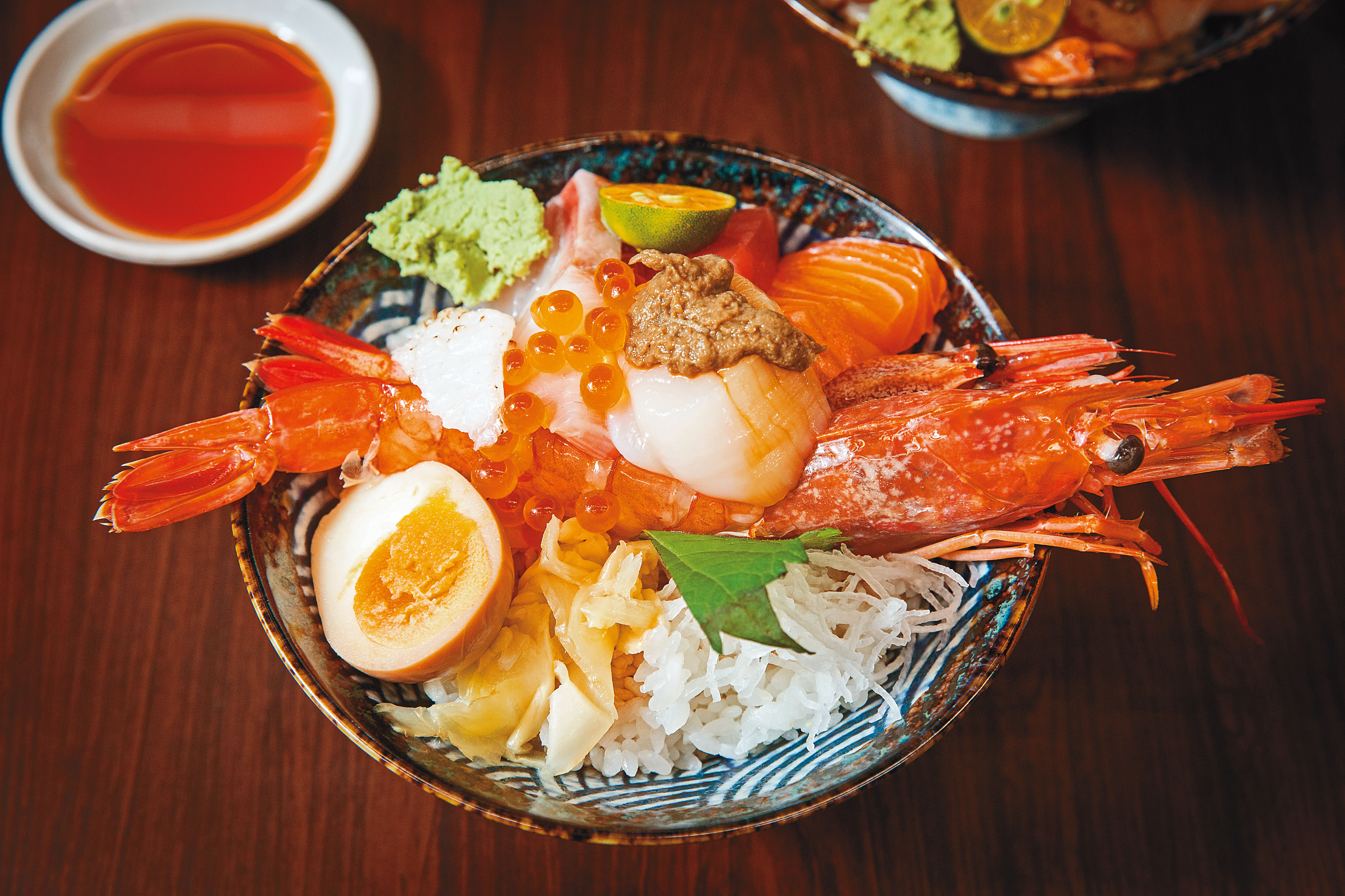 招牌「海神丼」以甜蝦、赤蝦雙拼鋪底，疊上蟹膏、干貝、海膽、鮭魚卵與3種生魚片，是店內的人氣料理。（420元／份）
