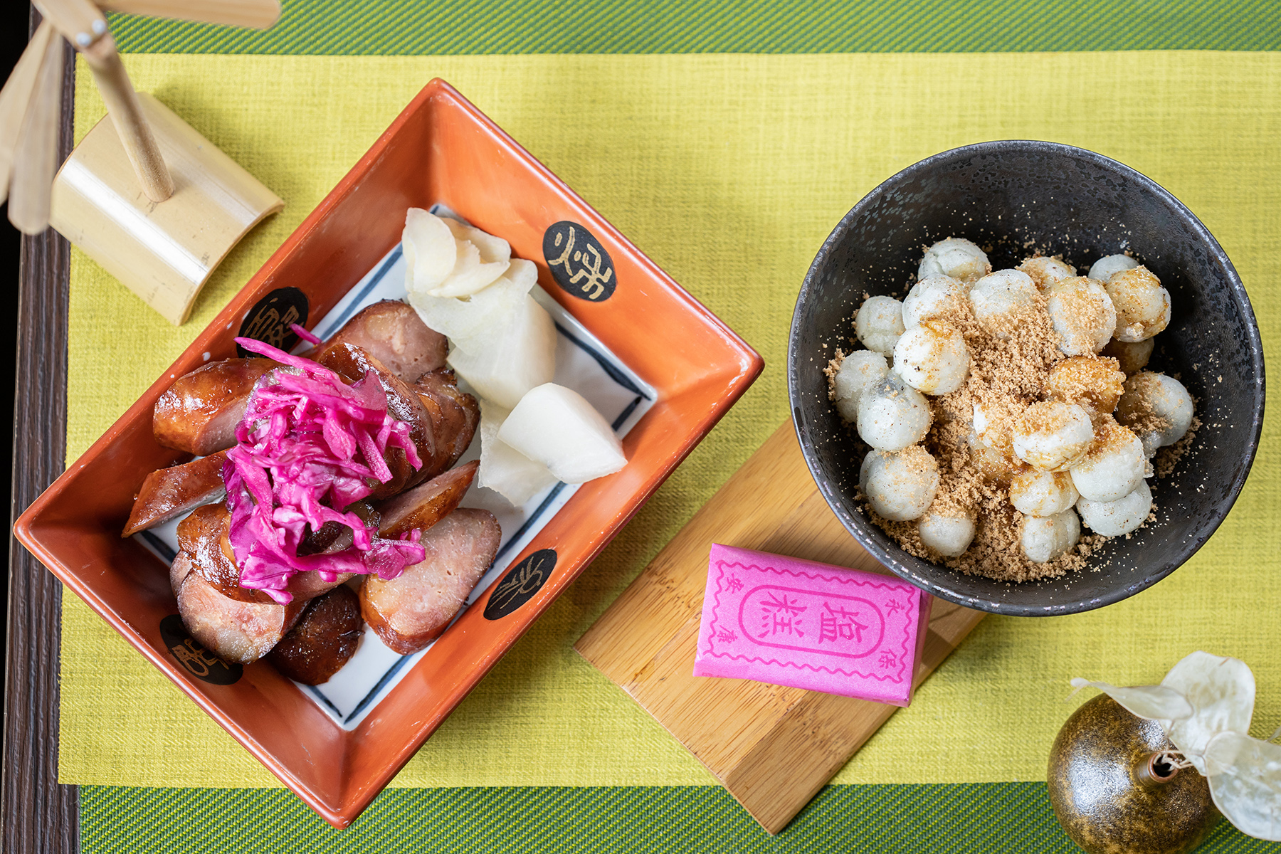 撒上新竹綠豆糕粉並搭配鹹糕一起享用的「雙味炸湯圓」（右，100 元／份），甜而不膩；「湖畔古早味烤香腸」（左，150元／份）浸泡滷肉湯後燒烤，滋味香醇濃厚。