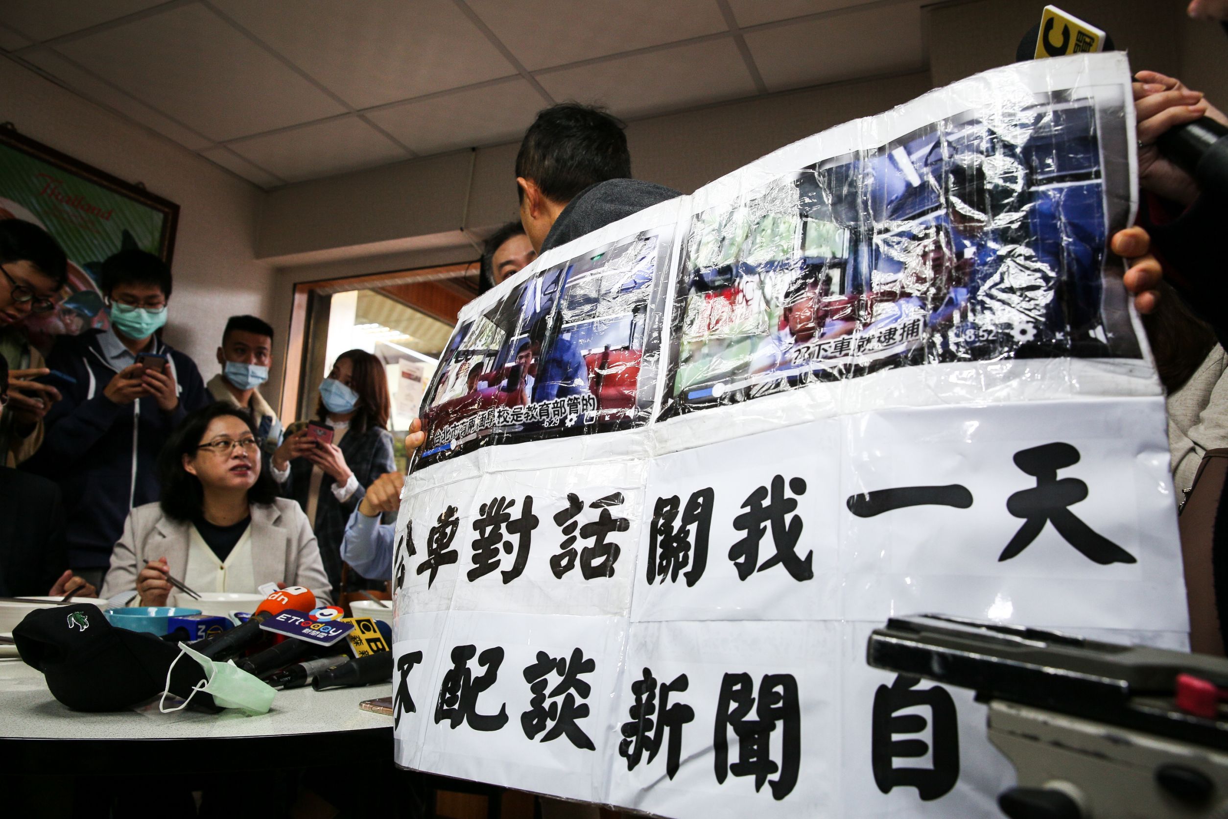 柯文哲吃麵一陣子後，台灣國辦公室主任陳峻涵拿著大字報衝上前抗議。