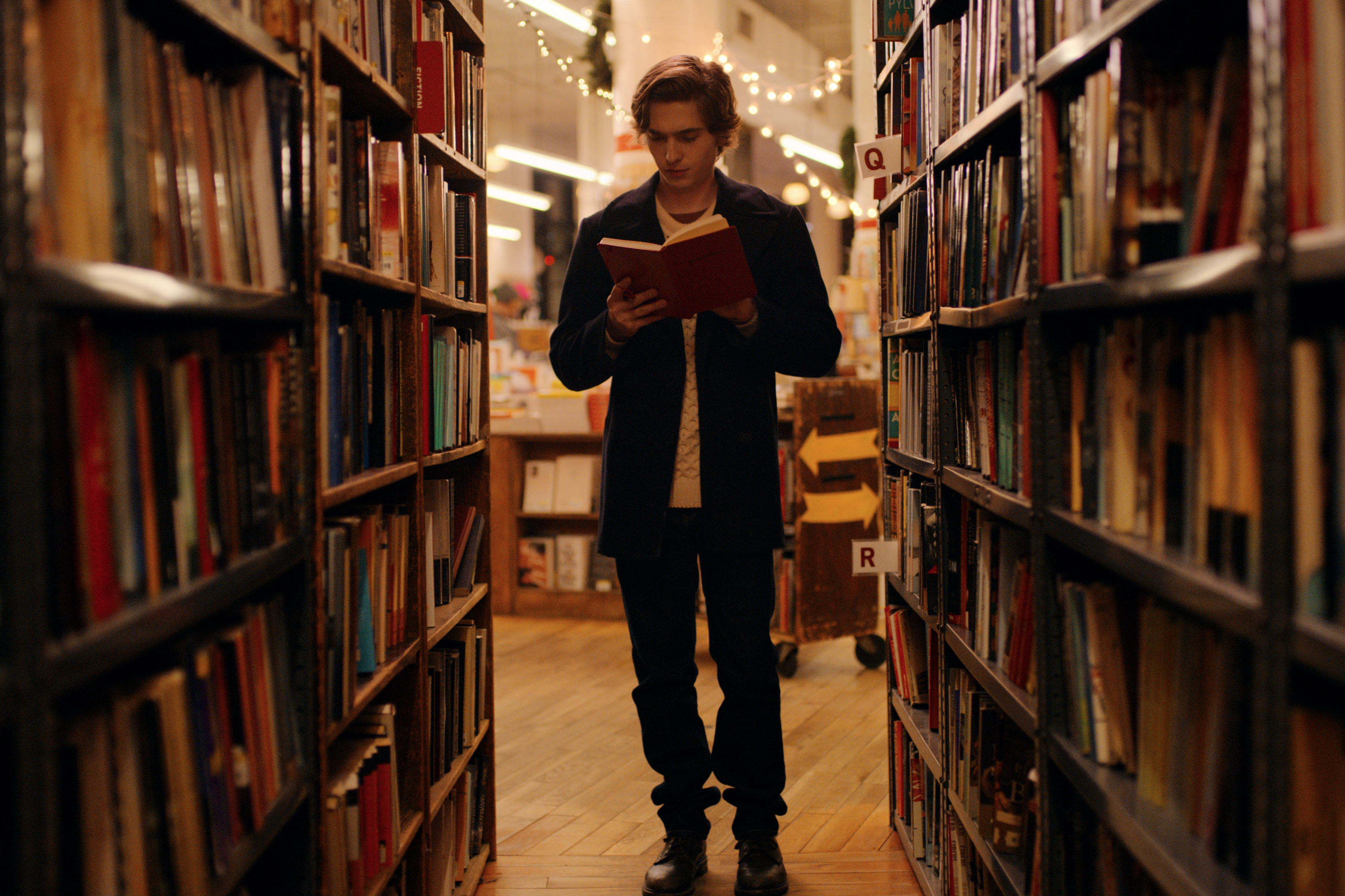 戴許在書店發現一本不該存在的紅色筆記本，原來裡頭是用謎題寫成的徵友啟事。（Netflix提供）