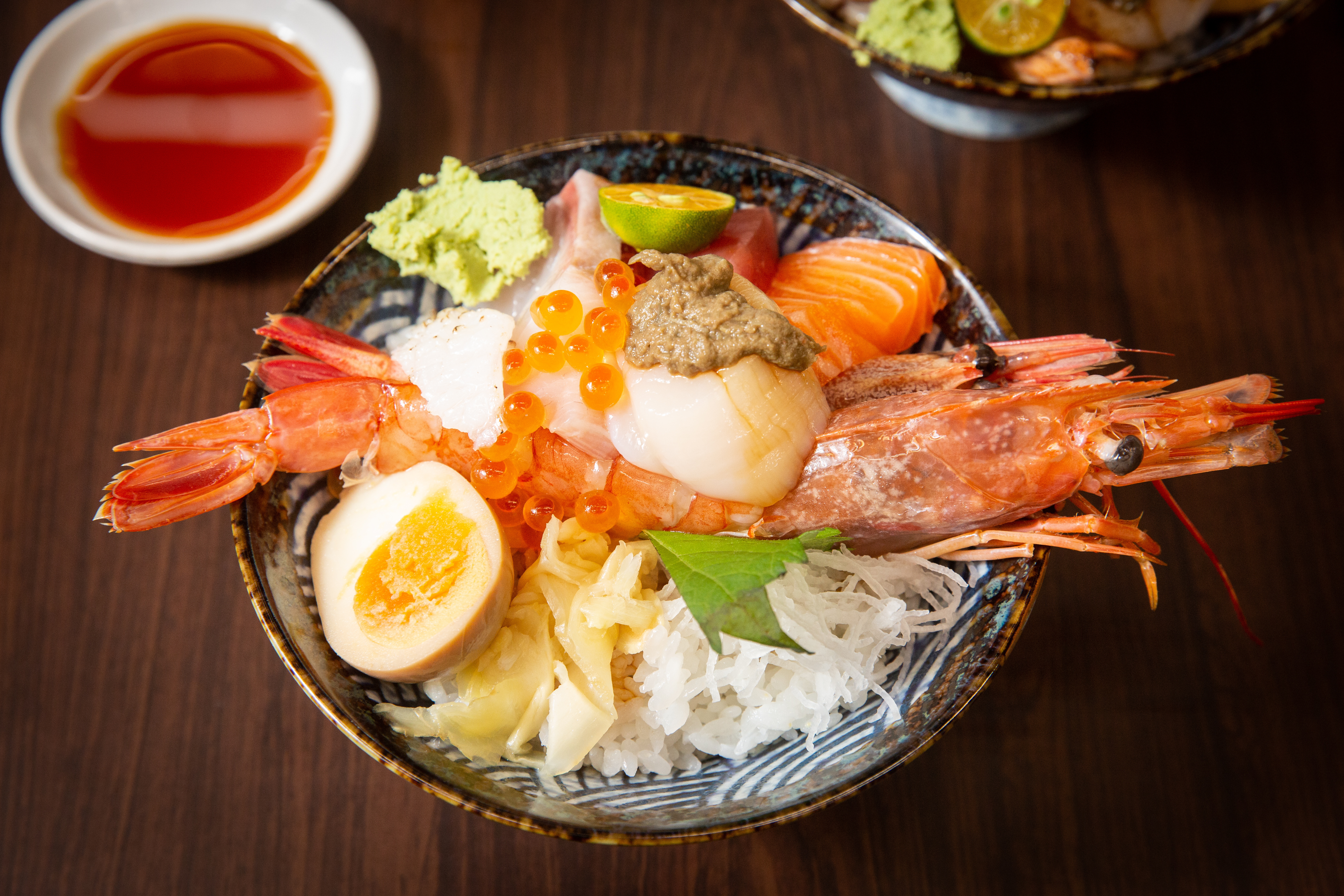 招牌「海神丼」以甜蝦、赤蝦雙拼鋪底，疊上蟹膏、干貝、海膽、鮭魚卵與3種生魚片，是店內的人氣料理。（420元/份）