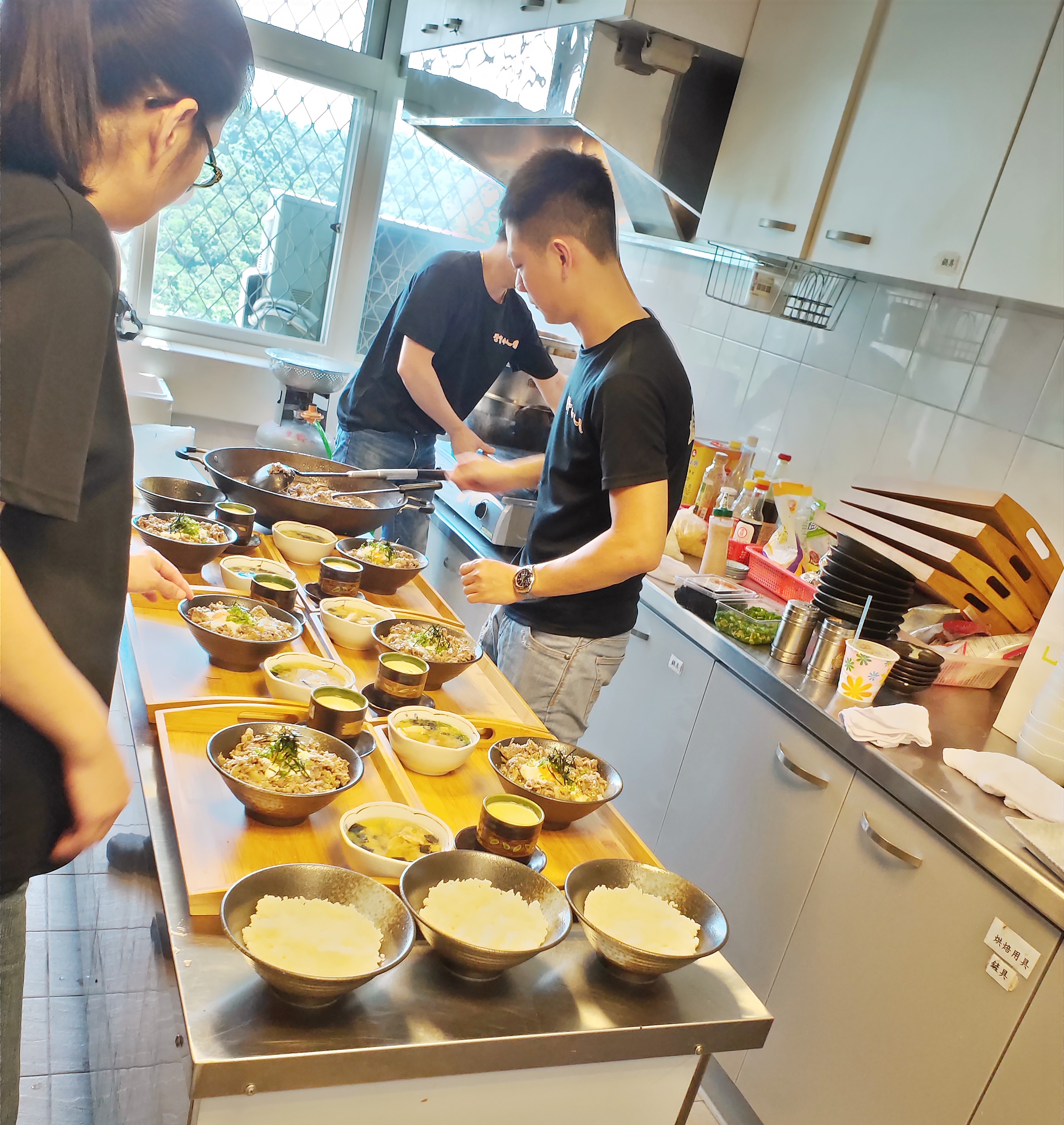 陳煥傑（右1）希望和院童分享對料理的熱情，這2年暑假他都會抽空回育幼院義煮，讓孩子們嘗嘗美味丼飯。（忠義基金會提供）