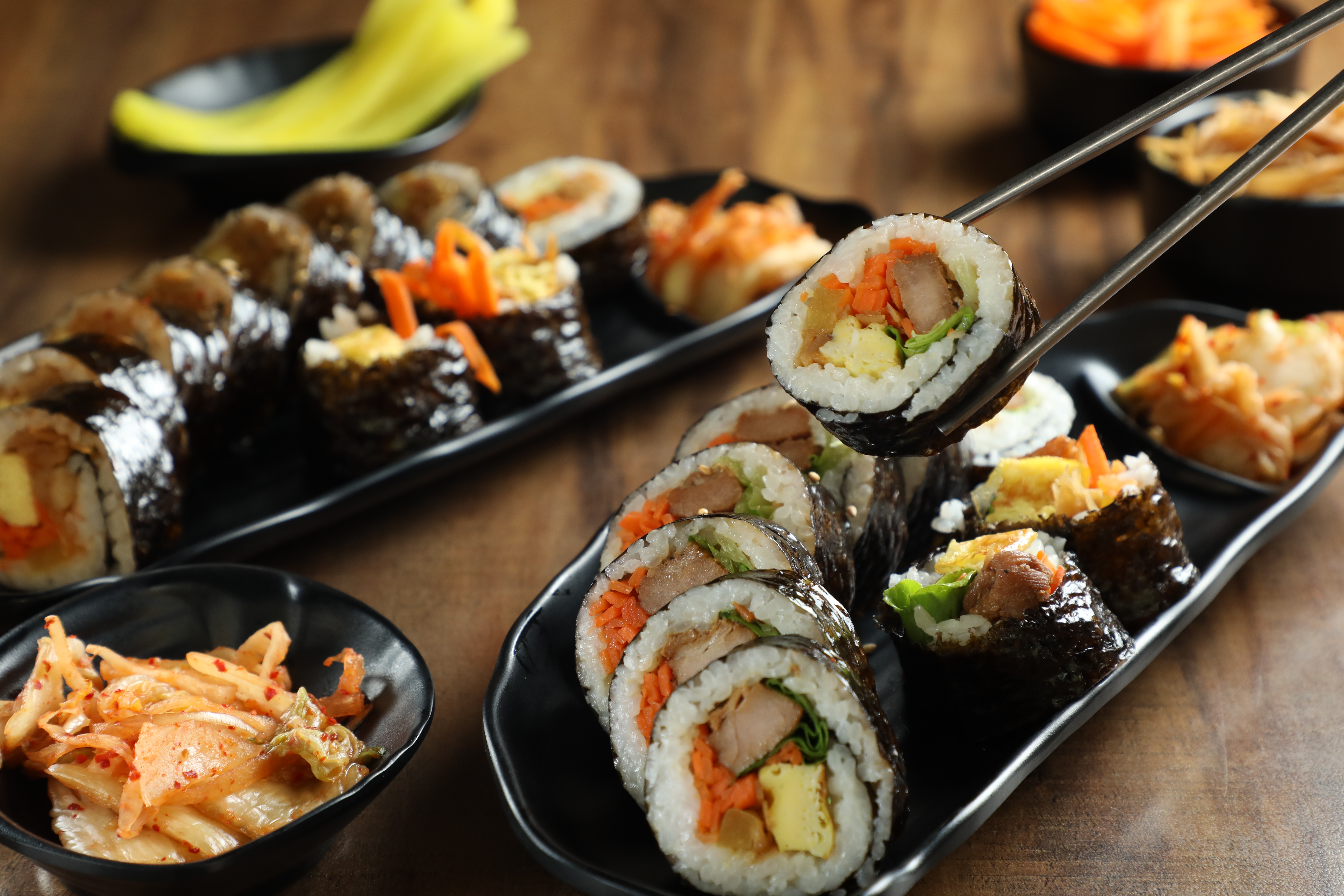 「韓國壽司」剖面，配料、顏色分布均勻，米飯要拌芝麻油，海苔也塗抹芝麻油，油油亮亮、散發濃郁芝麻香，才道地。（皆120元／份，前為燒肉口味，左後為泡菜口味）