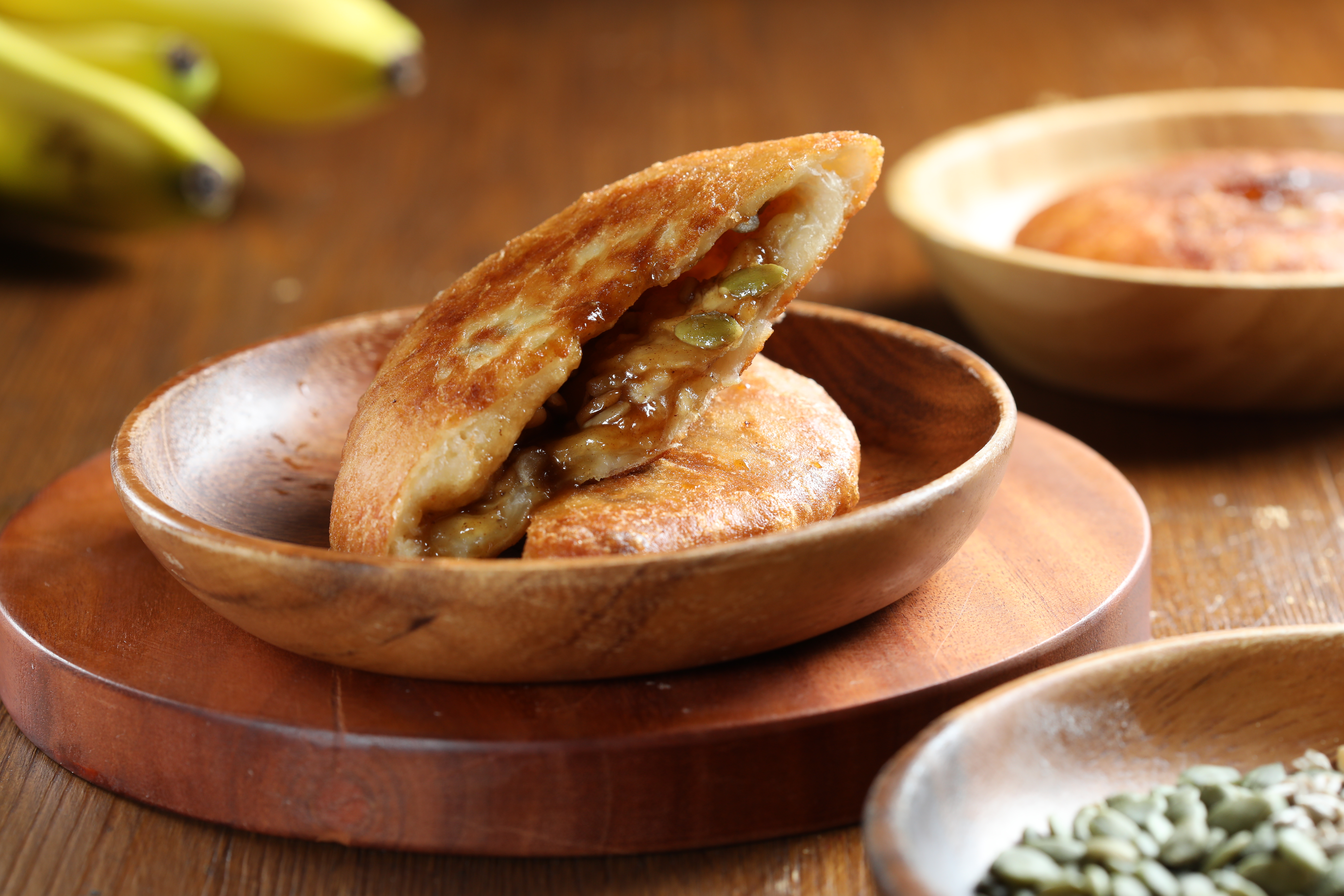 「香蕉蜜糖堅果糖餅」在經典款放入新鮮香蕉切片，散發水果的甜熟。（80元／個，木盤為拍照示意，內用以紙杯盛裝）