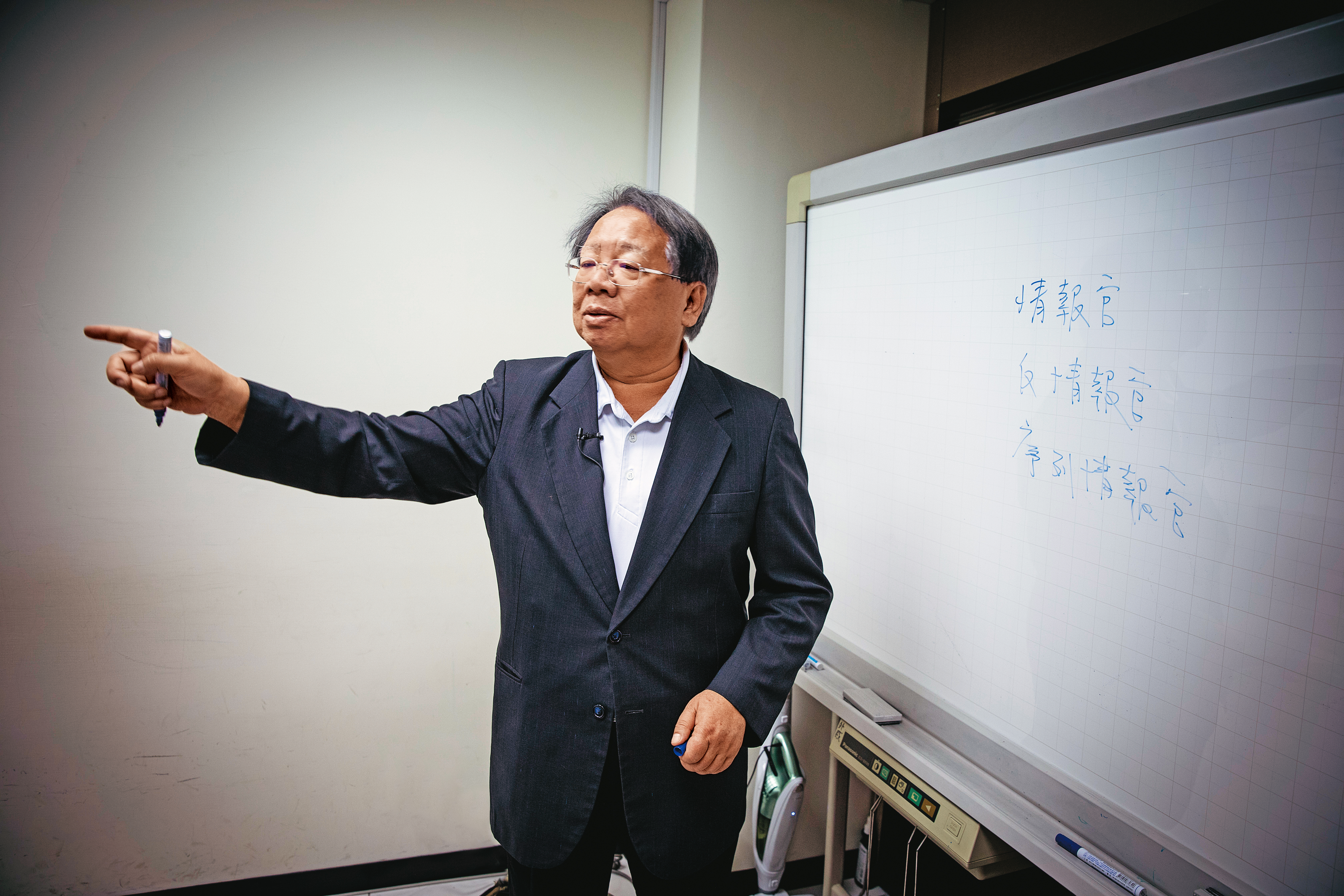 台灣戰略模擬學會小小的會議室中，有一大塊白板，張榮豐談起戰略，常不小心就把白板寫得密密麻麻。他為人謹慎，這天知道我們要拍攝，擦去較敏感的說明文字。