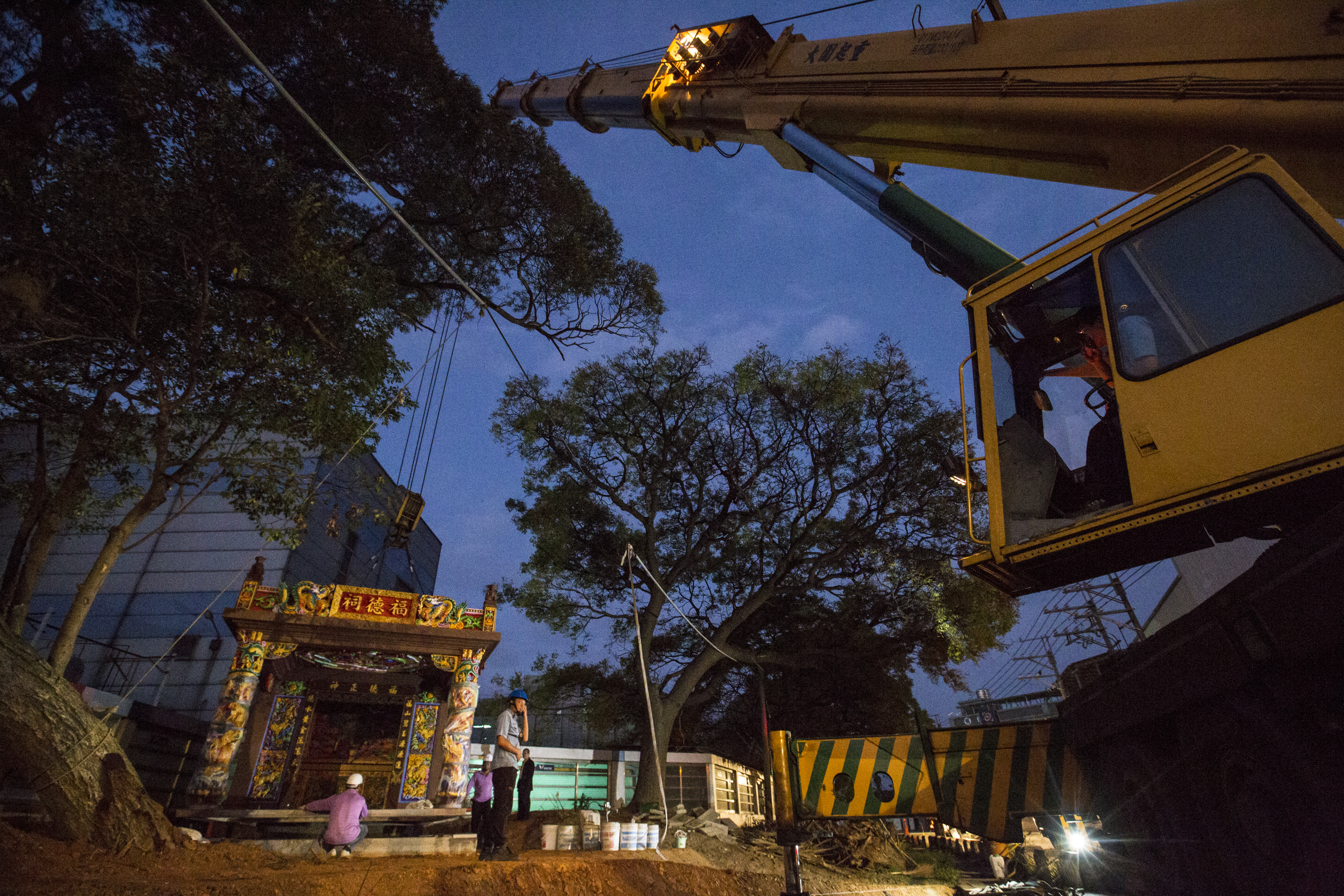 林復準把廟宇製作成可移動、拆解再組合式建築，待吊車掛勾掛上廟宇屋頂後，便能騰空而起，緩緩穿過2顆樹中間，不偏不倚地落在風水師指定的基座上。