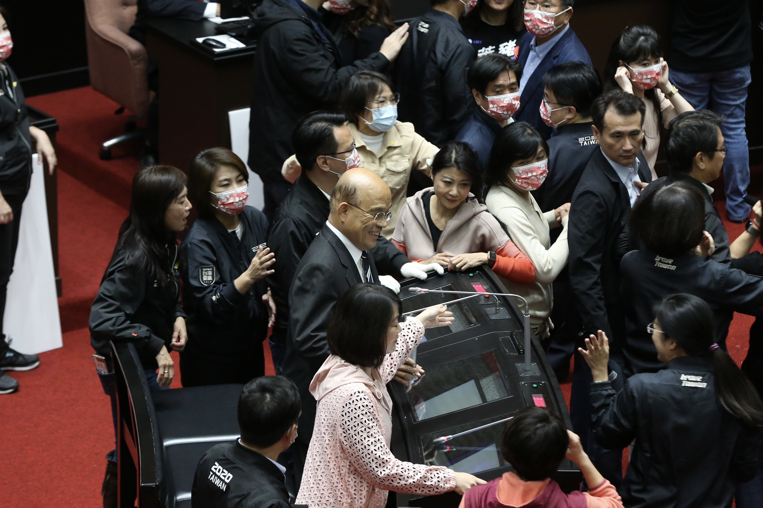 蘇貞昌在綠委團團保護下站上備詢台。