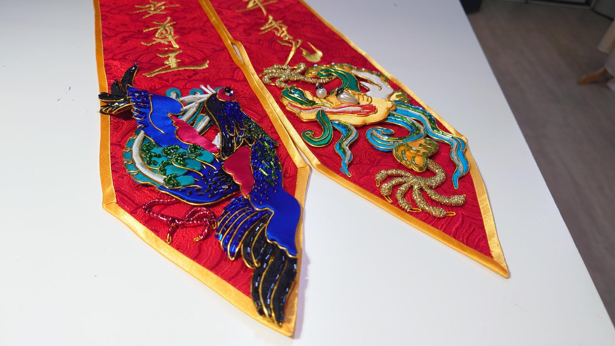 劇場服裝設計師李育昇精心打造的紅綾,左為祥瑞的五爪正龍,右則象徵鳳凰的台灣特有種「藍腹鷴」。(文化總會提供)