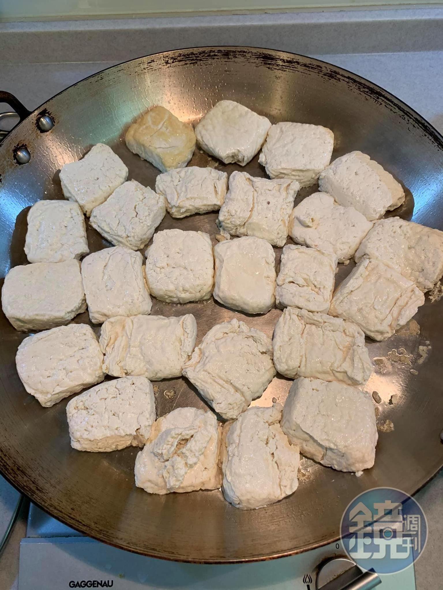 將臭豆腐入鍋一面煎黃，另一面略煎上色。