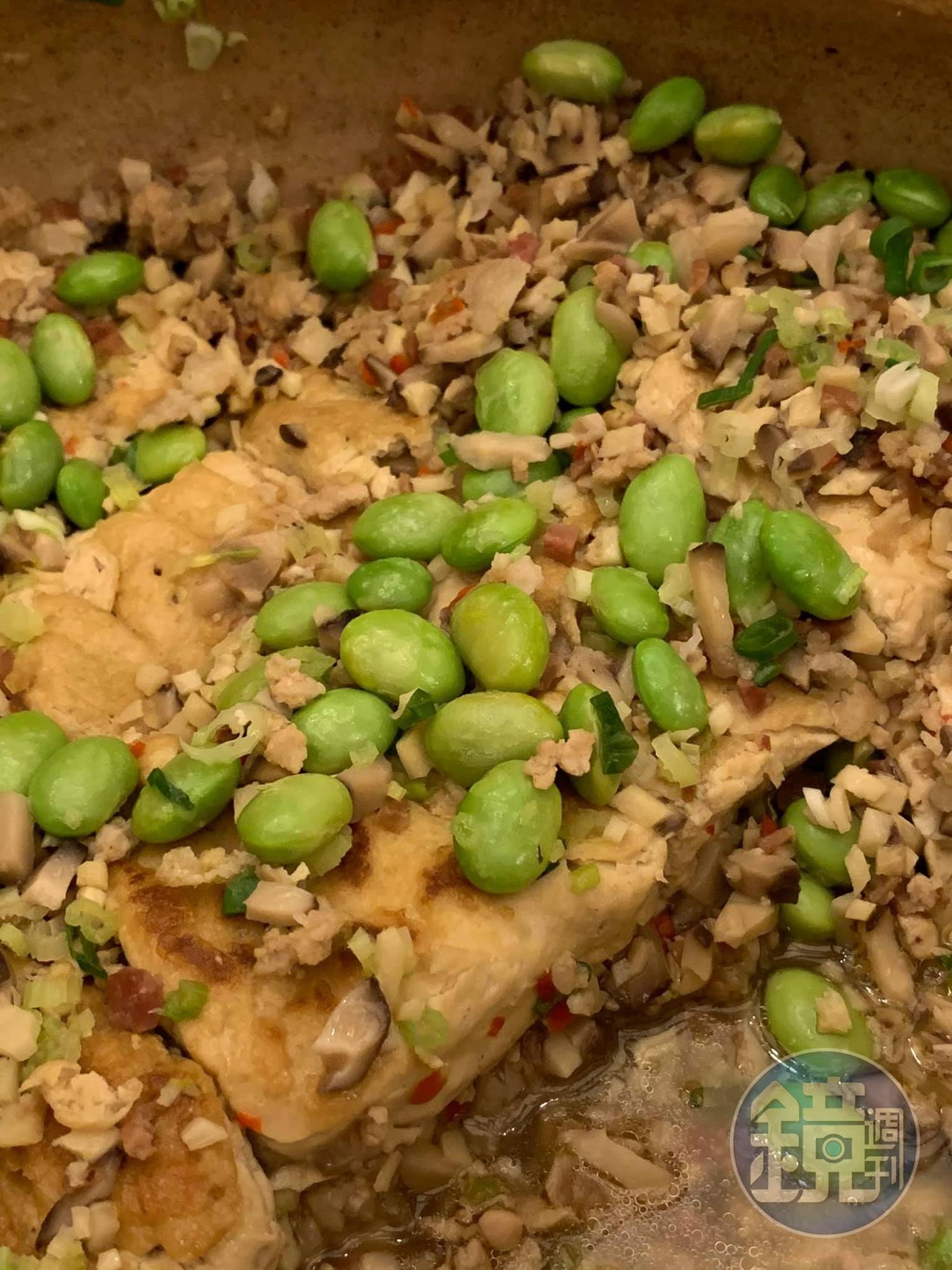 毛豆覆蓋下，隱約可見吸飽了湯汁的臭豆腐。