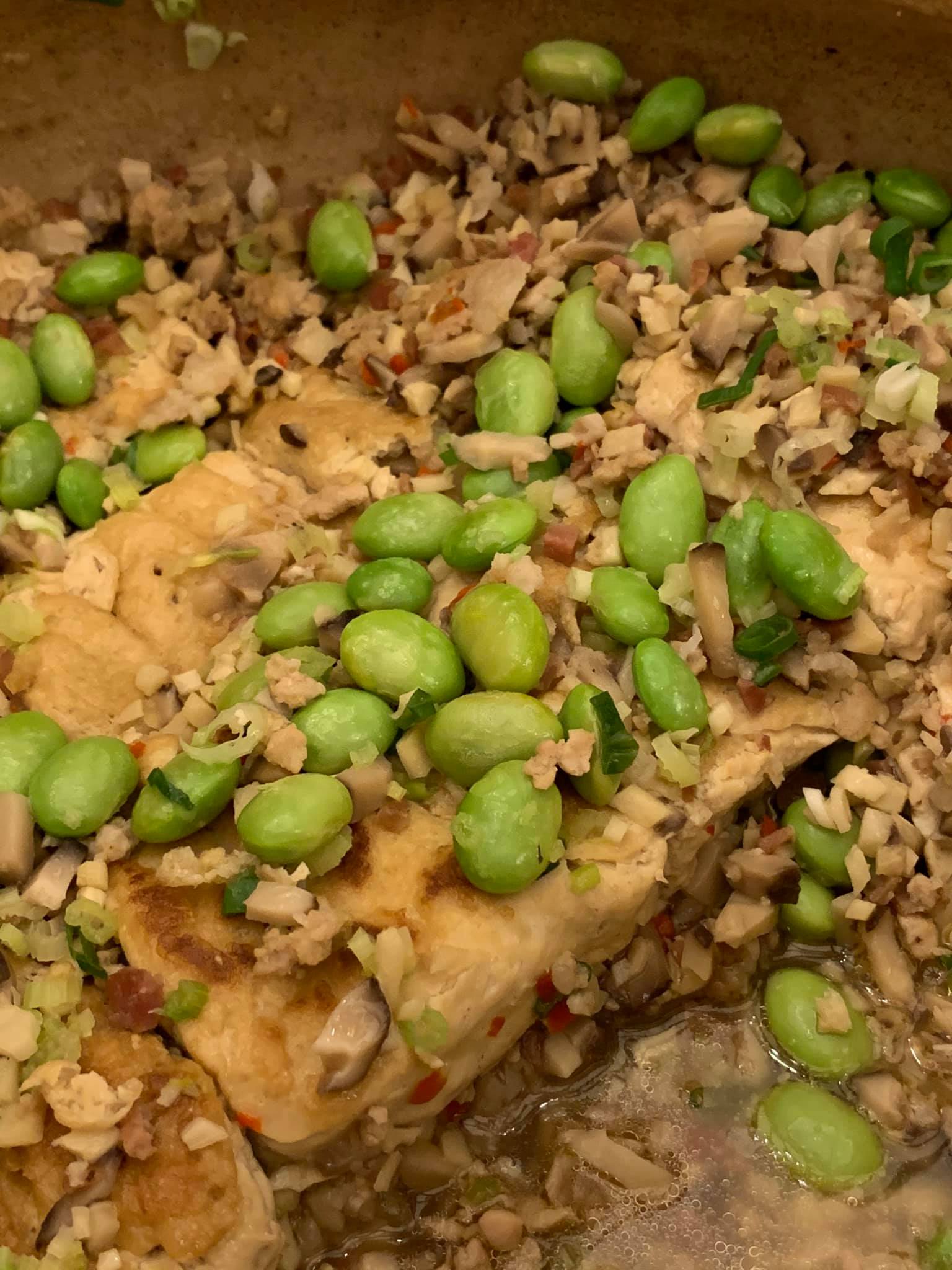 毛豆覆蓋下，隱約可見吸飽了湯汁的臭豆腐。