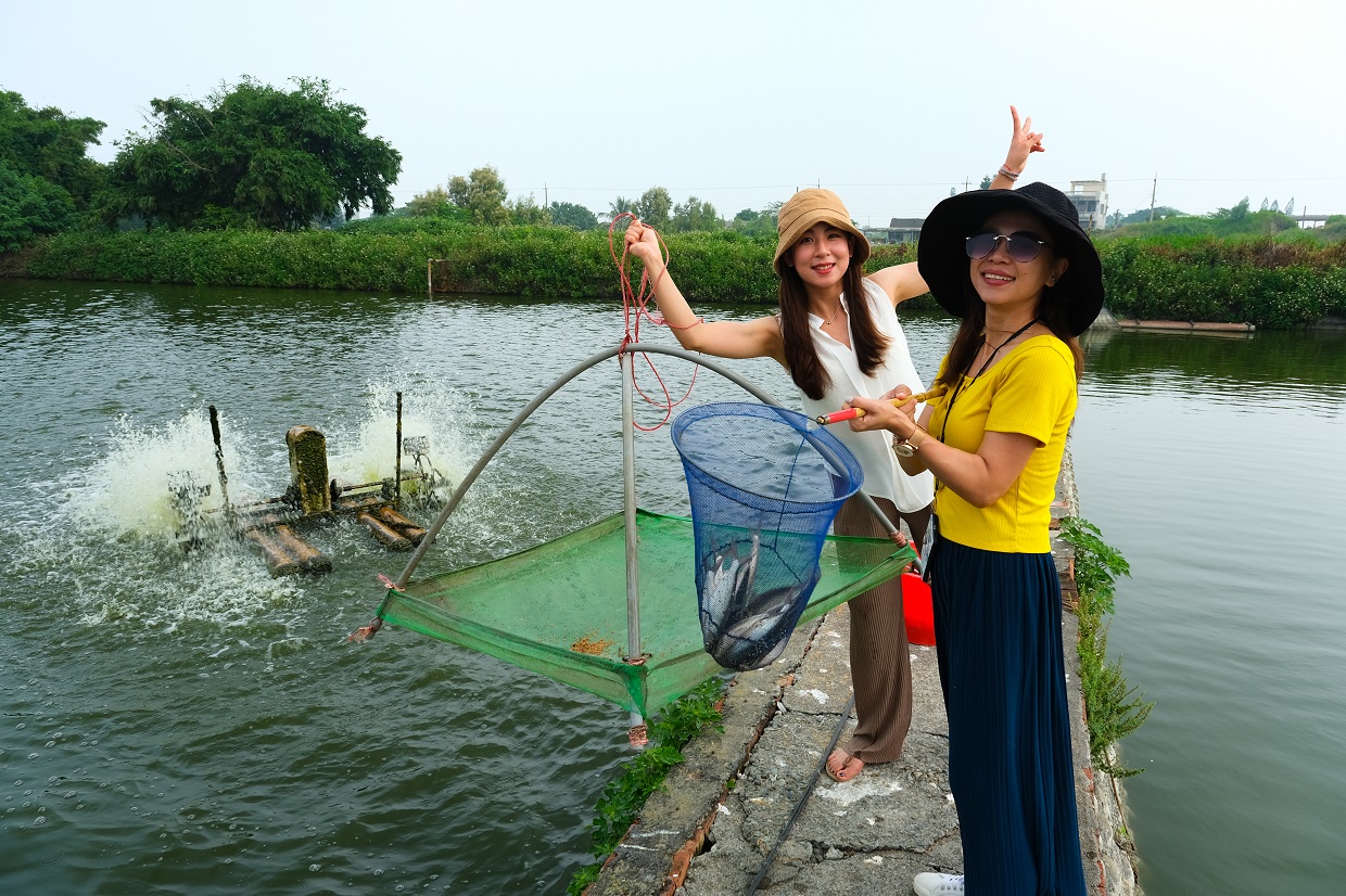 遊客手拿蝦網和手網，進行有趣的「好蝦冏男社」蝦事體驗。