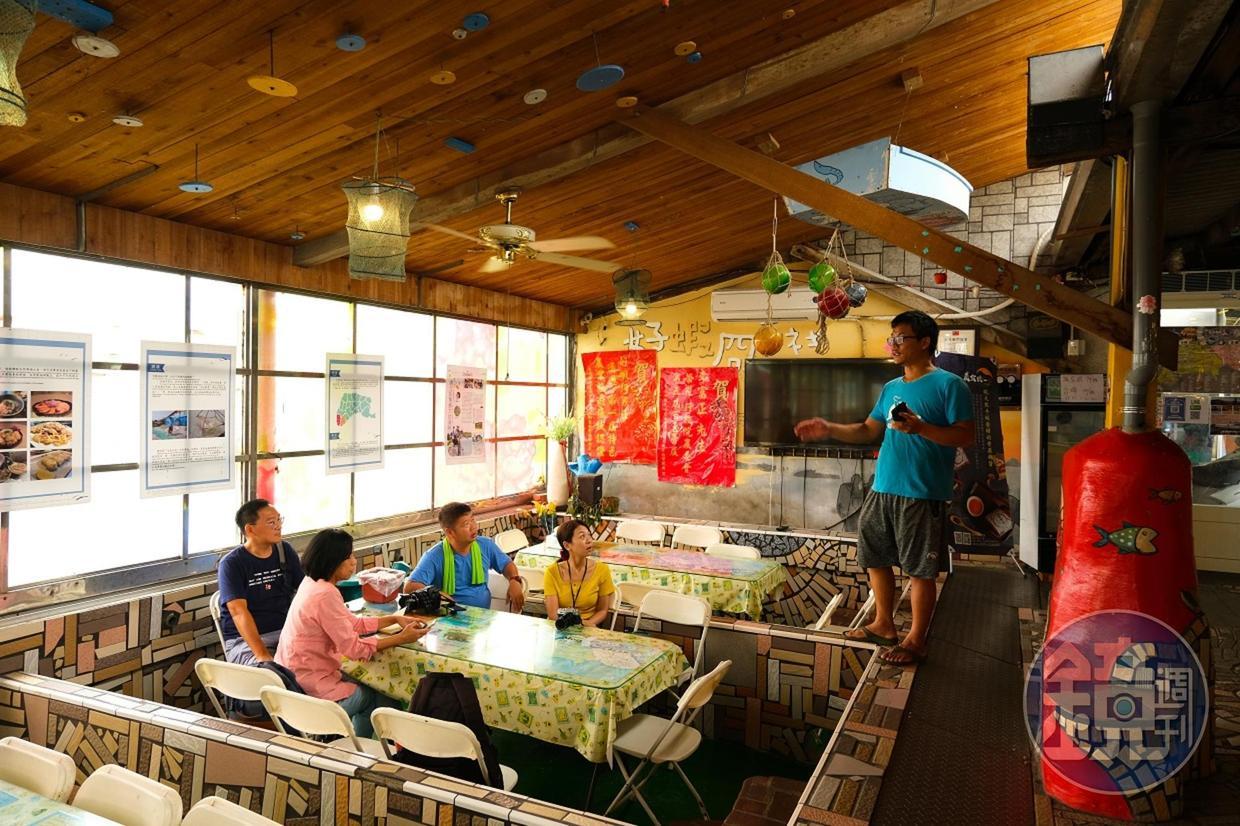 遊客坐在池塘餐廳內，聽老闆阿正教大家如何分辨好蝦。