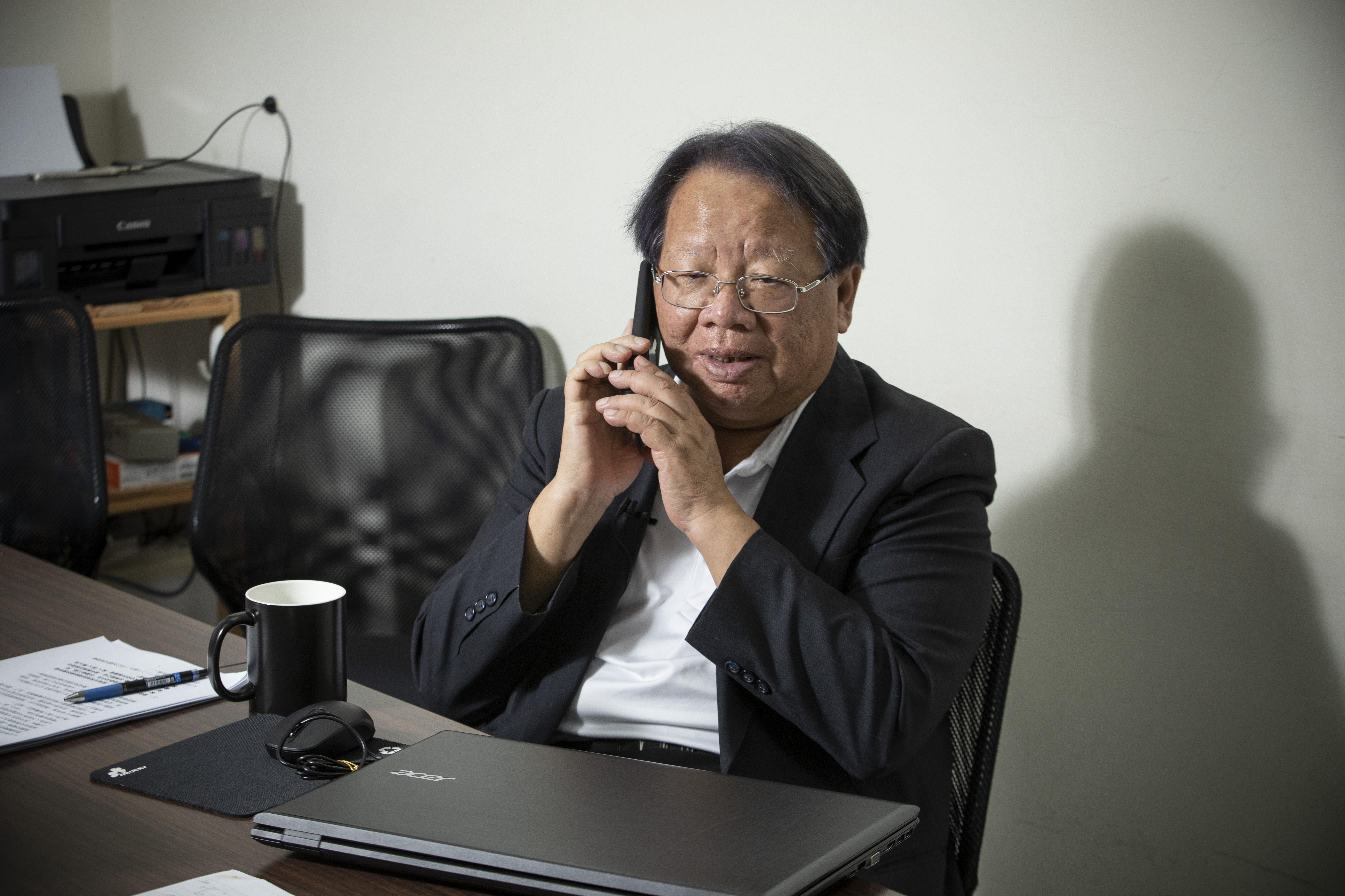 張榮豐受訪時隨手接起電話。如今他習慣打免費的Line電話，其實不過30年前，他的家用電話還被總統府「長途台」的「萬能先生」監聽。