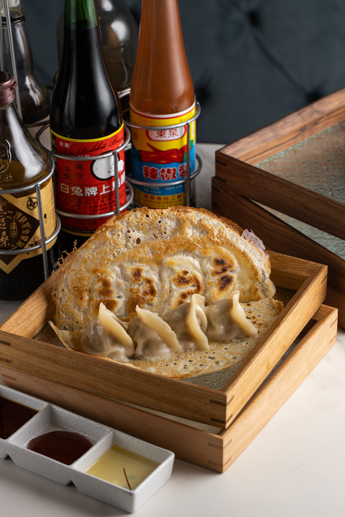 帶著立挺酥脆冰花登場的「剝皮辣椒鮮肉煎餃」，搭配香檳解辣增香。（240元／份）