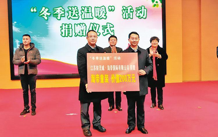 淘帝董事長周訓財(左2)自稱在中國常做善事,曾捐出市值人民幣200萬元的童裝給弱勢民眾。(翻攝網路)