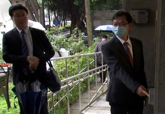 凱羿公司前董座蔡謀燦（右）由律師陪同到新北地檢署按鈴申告。（翻攝畫面）