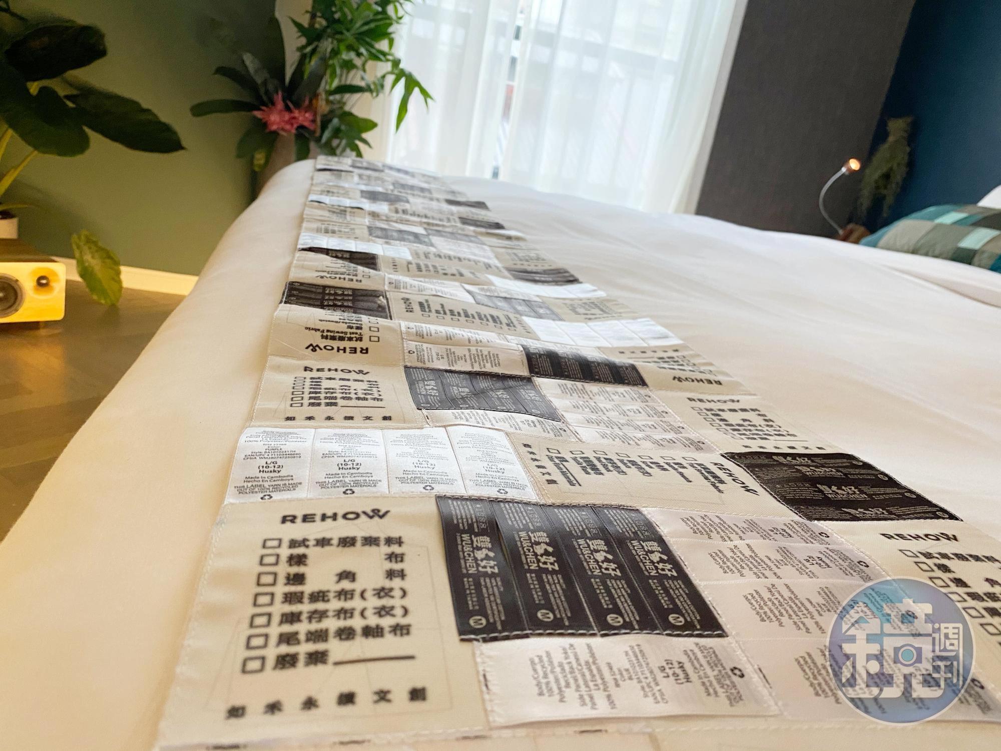 黑白色調床尾巾由大量洗標拼接。