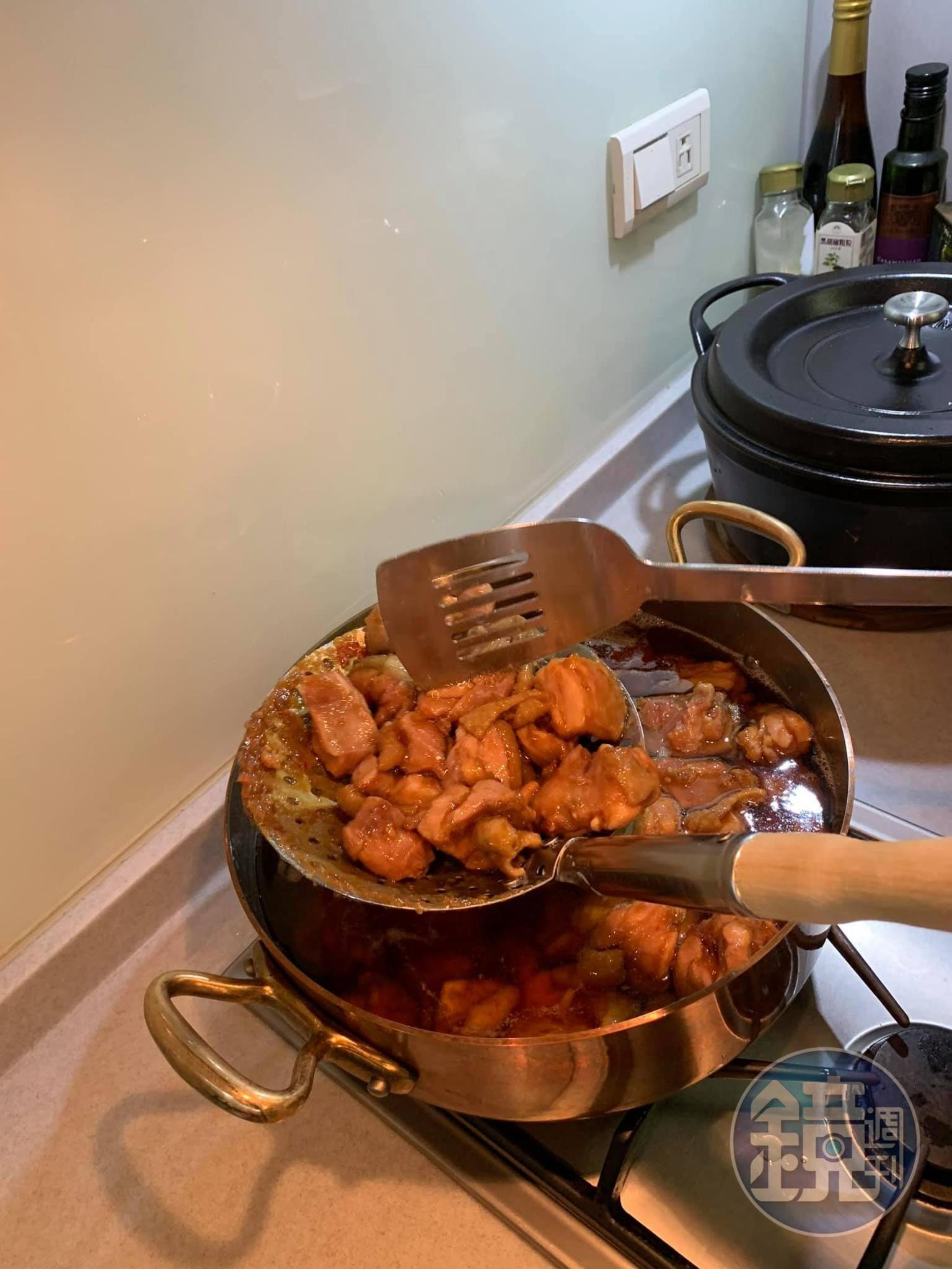 撈起雞塊，用鏟子敲鬆肉塊。