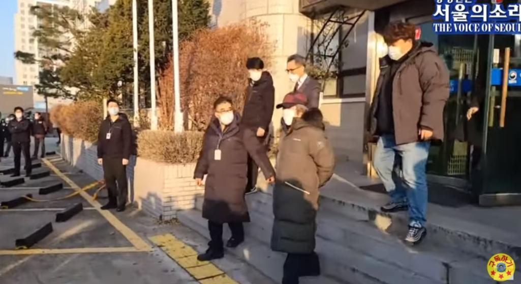 趙斗淳剛走出安山保護所，就將沒上銬的雙手背在後背。（翻攝自서울의 소리 The Voice of Seoul YouTube頻道）