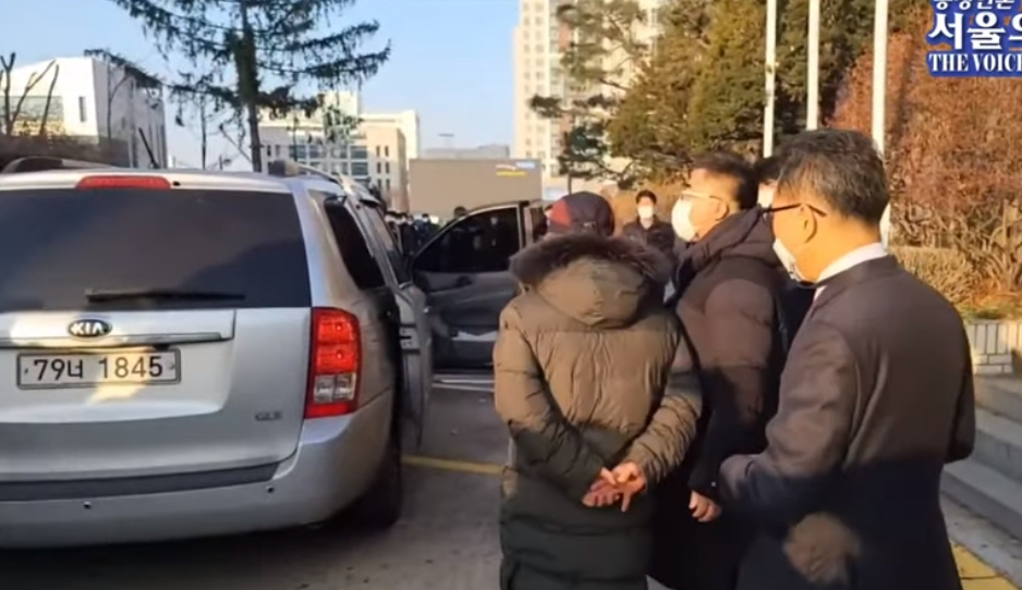 趙斗淳將沒上銬的雙手背在後背，該動作即使鞠躬道歉也未停下。（翻攝自서울의 소리 The Voice of Seoul YouTube頻道）