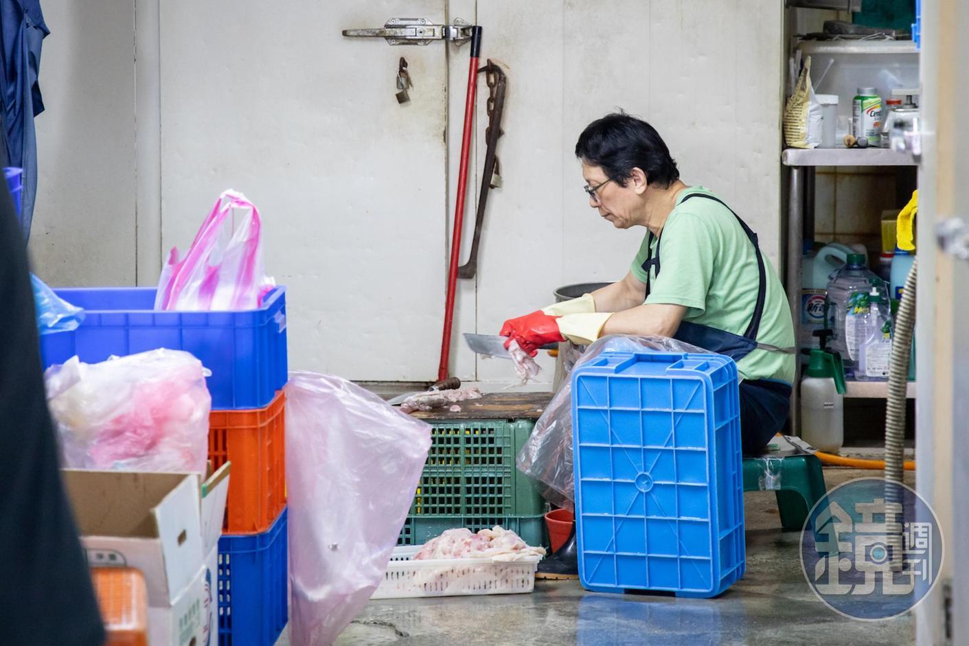 「朴子魚丸店」老闆在後頭蹲坐，費工刮著魚肉。