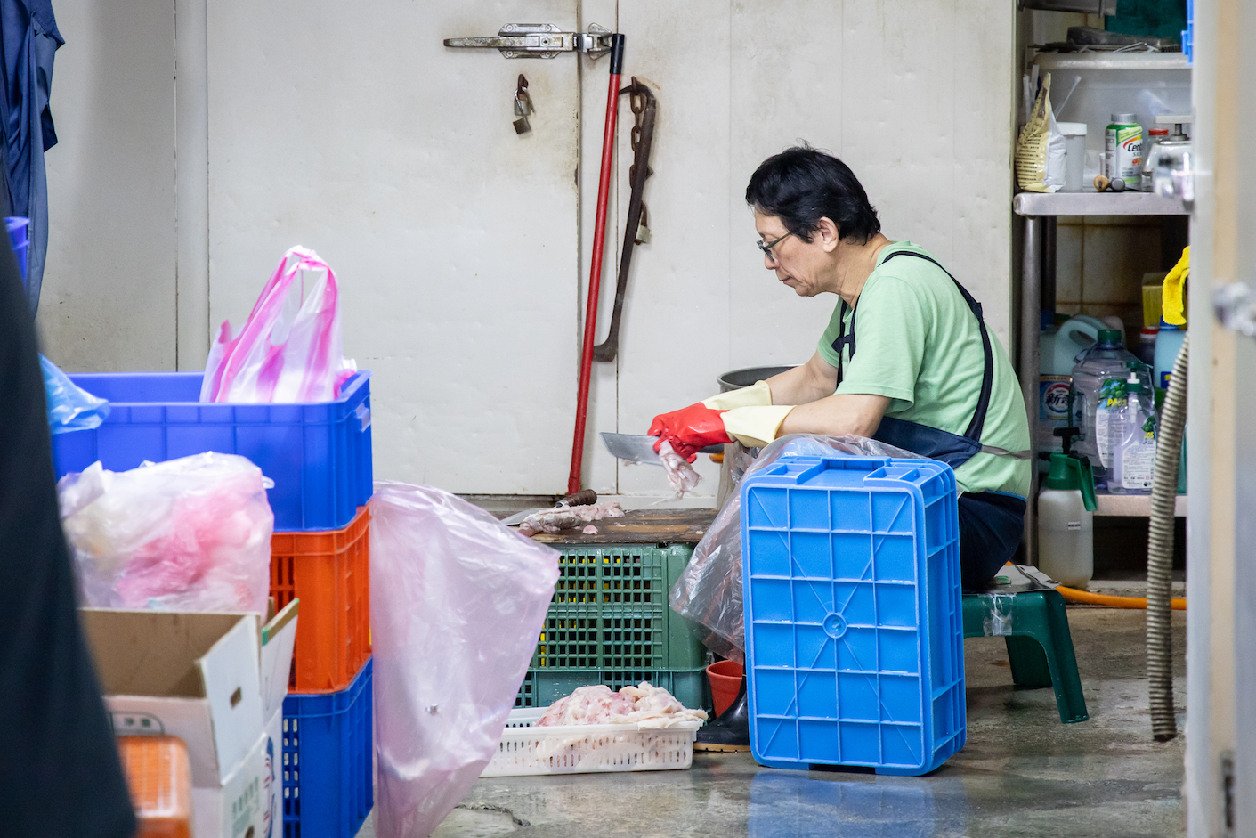 「朴子魚丸店」老闆在後頭蹲坐,費工刮著魚肉。