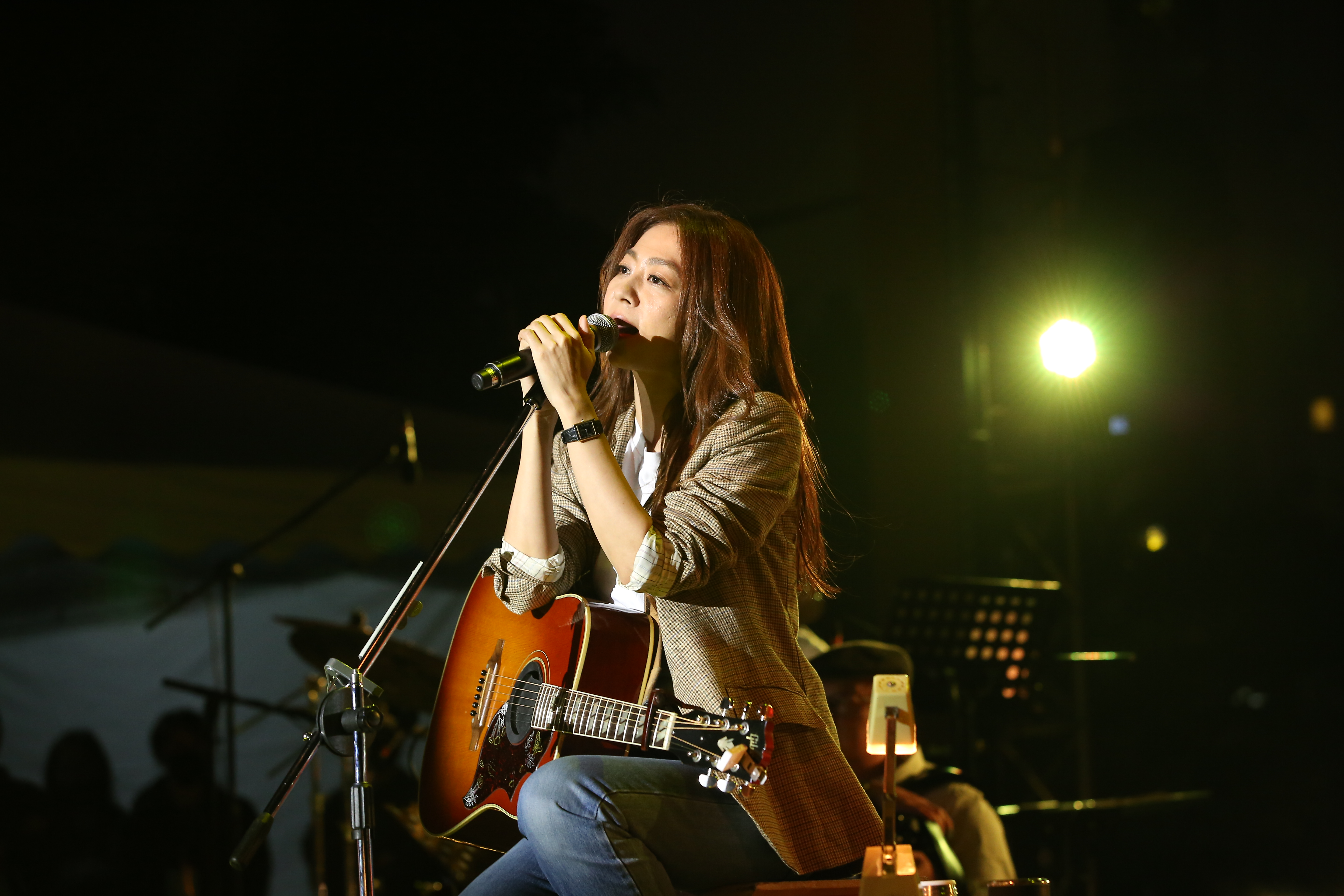 陳綺貞穿著格子外套與白上衣、牛仔褲，抱著吉他，為「2020 Simple Life Original 簡單生活節」做第一晚的壓軸演出。