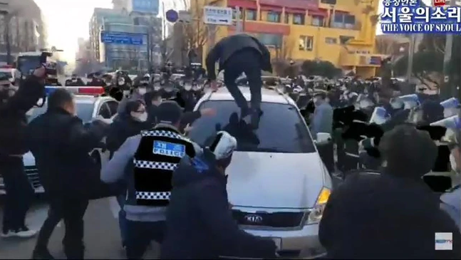 趙斗淳12日出獄，民眾跳上他乘坐的公務車洩憤。（翻攝The Voice of Seoul YouTube頻道）
