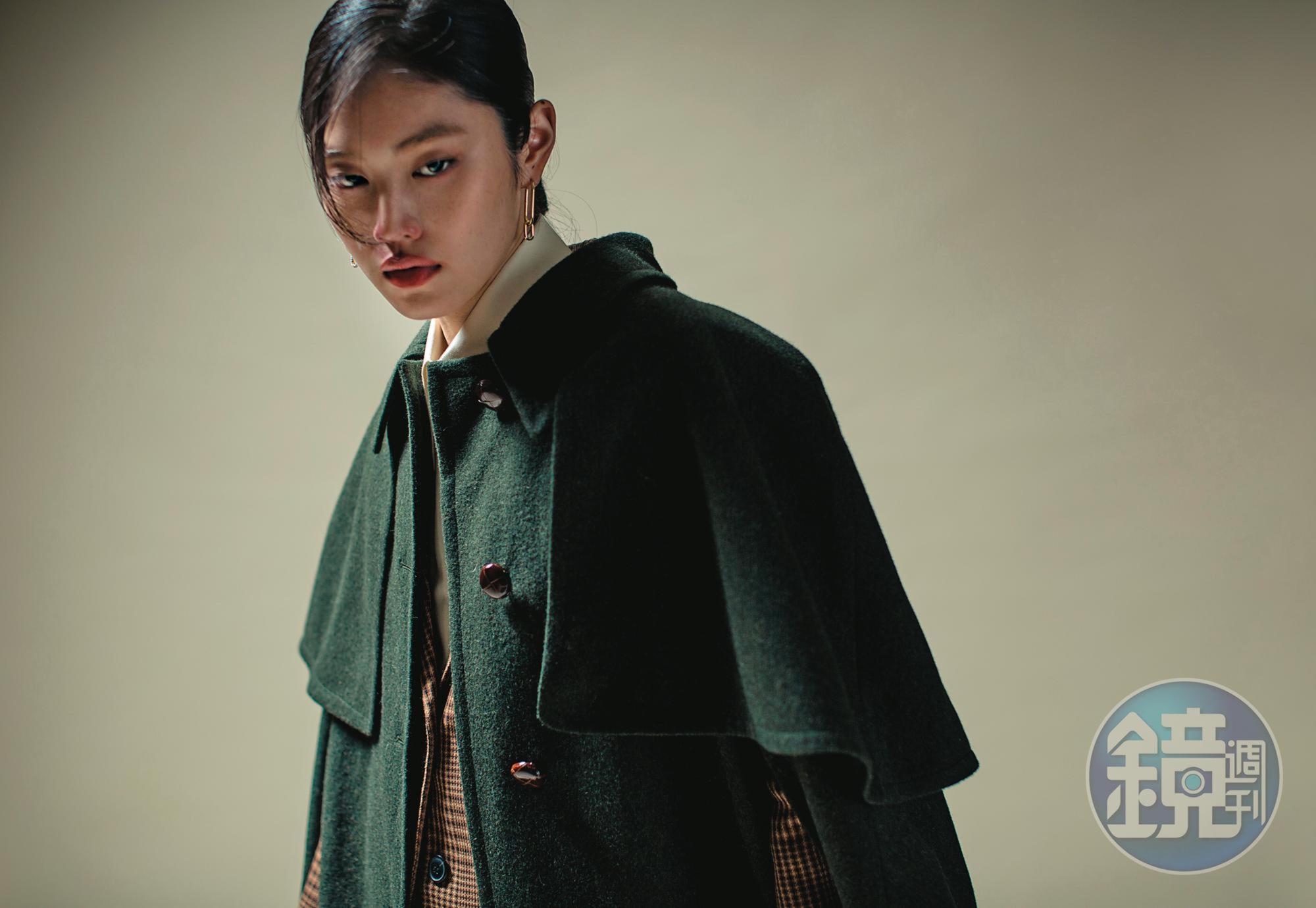 墨綠色斗篷 NT$110,000 by GUCCI／格紋西裝外套 NT$15,070 by MAJE／米白色襯衫 NT$42,000 by GUCCI／TIME穿孔耳環 NT$4,990 by SWAROVSKI