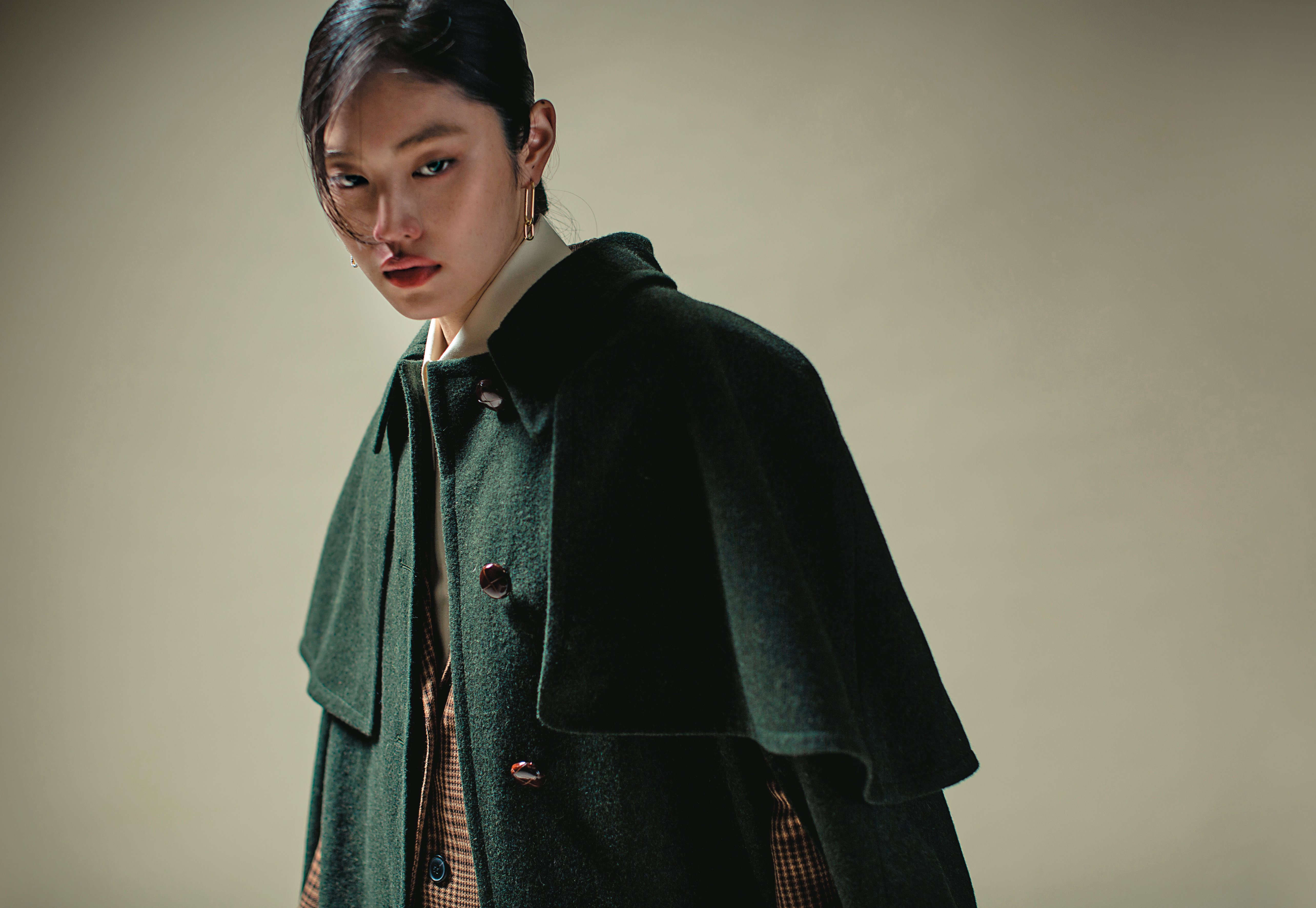 墨綠色斗篷 NT$110,000 by GUCCI／格紋西裝外套 NT$15,070 by MAJE／米白色襯衫 NT$42,000 by GUCCI／TIME穿孔耳環 NT$4,990 by SWAROVSKI