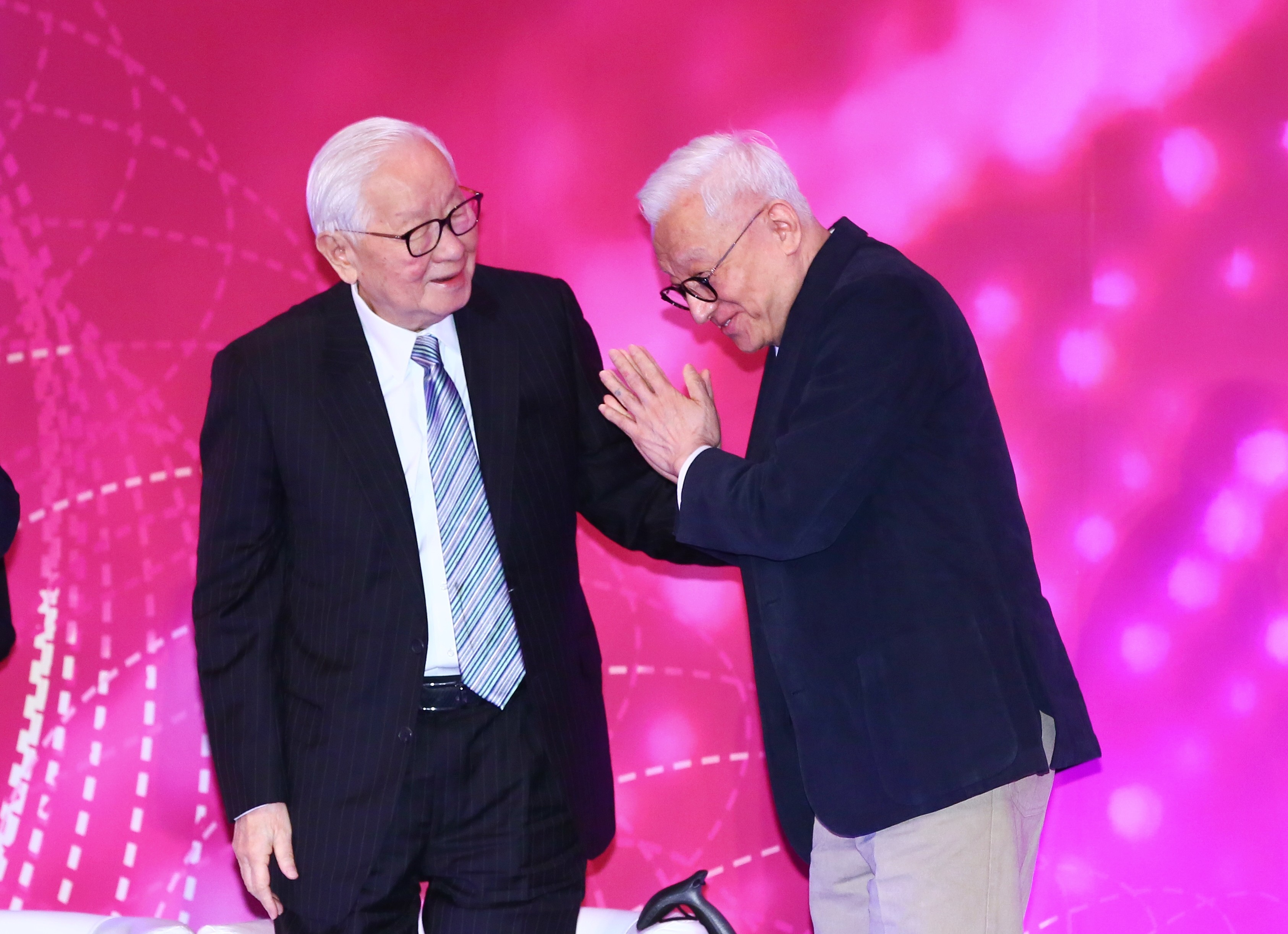 聯電榮譽董事長曹興誠（右）主動趨前與台積電創辦人張忠謀（左）握手致意，留下罕見同台畫面。