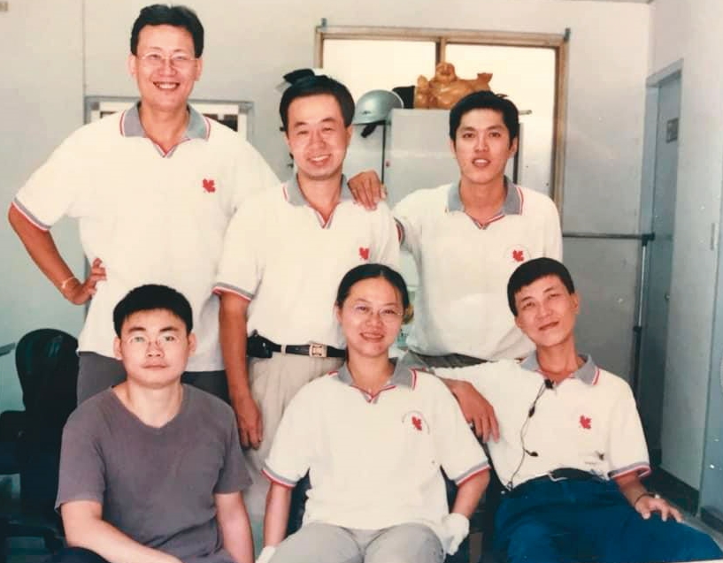 豐業物流創立第3年,股東皆退股,獨留黃世杰(後右)苦撐,當時員工只有8人,至今僅剩轉運中心主任馮訓銘(後左)還在任。(黃世杰提供)