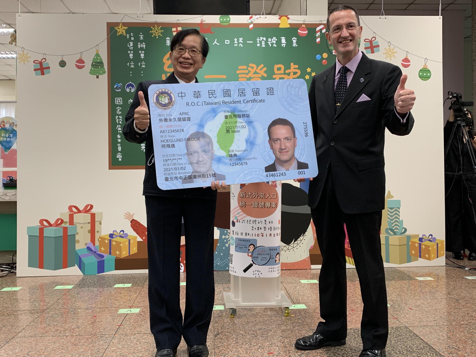 內政部次長邱昌嶽(左)頒給歐洲商會執行長何飛逸(右)新式統一證號居留證樣卡。(移民署提供)