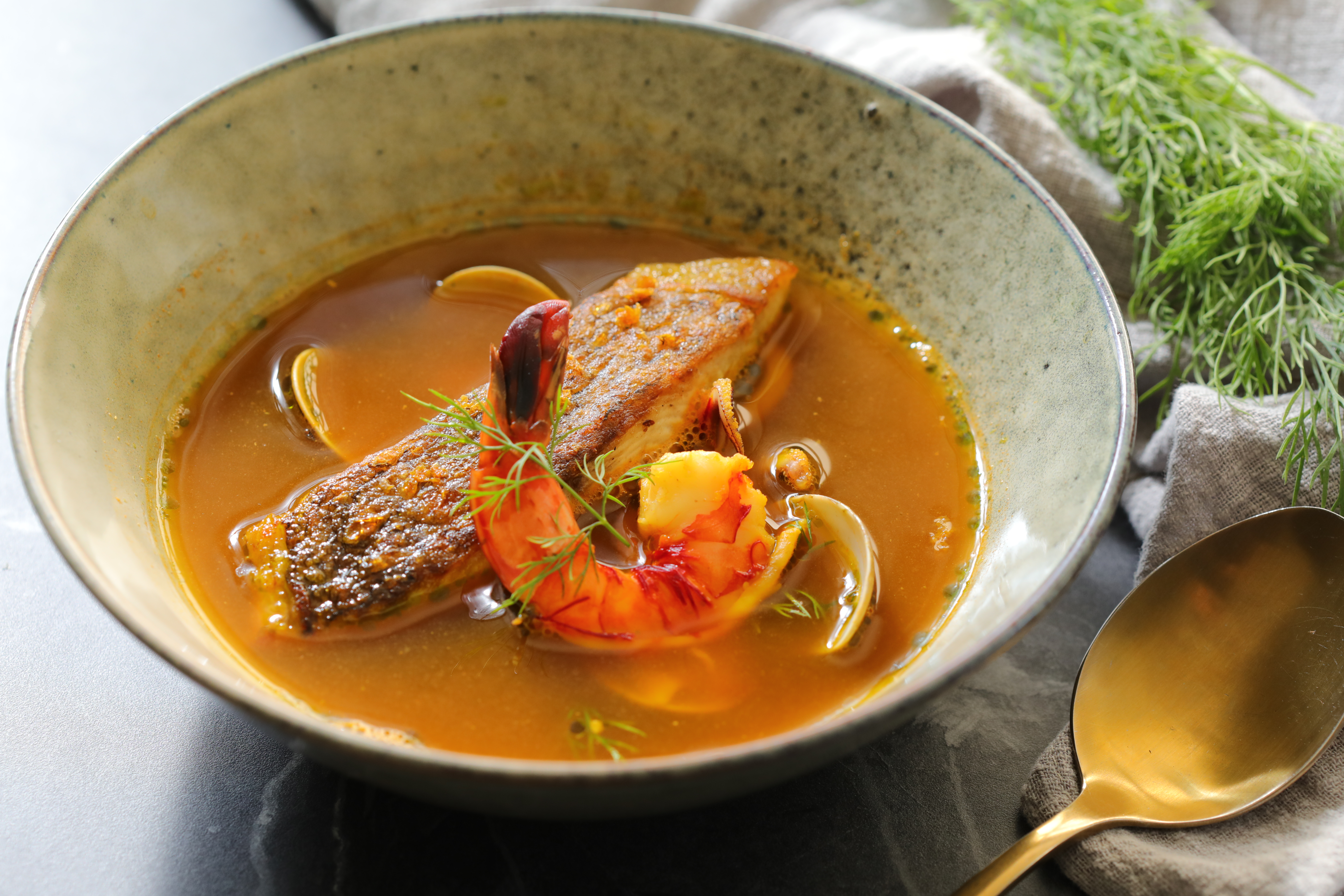 「番紅花海鮮魚湯」湯底鮮美來自烤魚骨和蝦頭，點上檸檬油、柑橘皮，格外清爽。（380元／份）