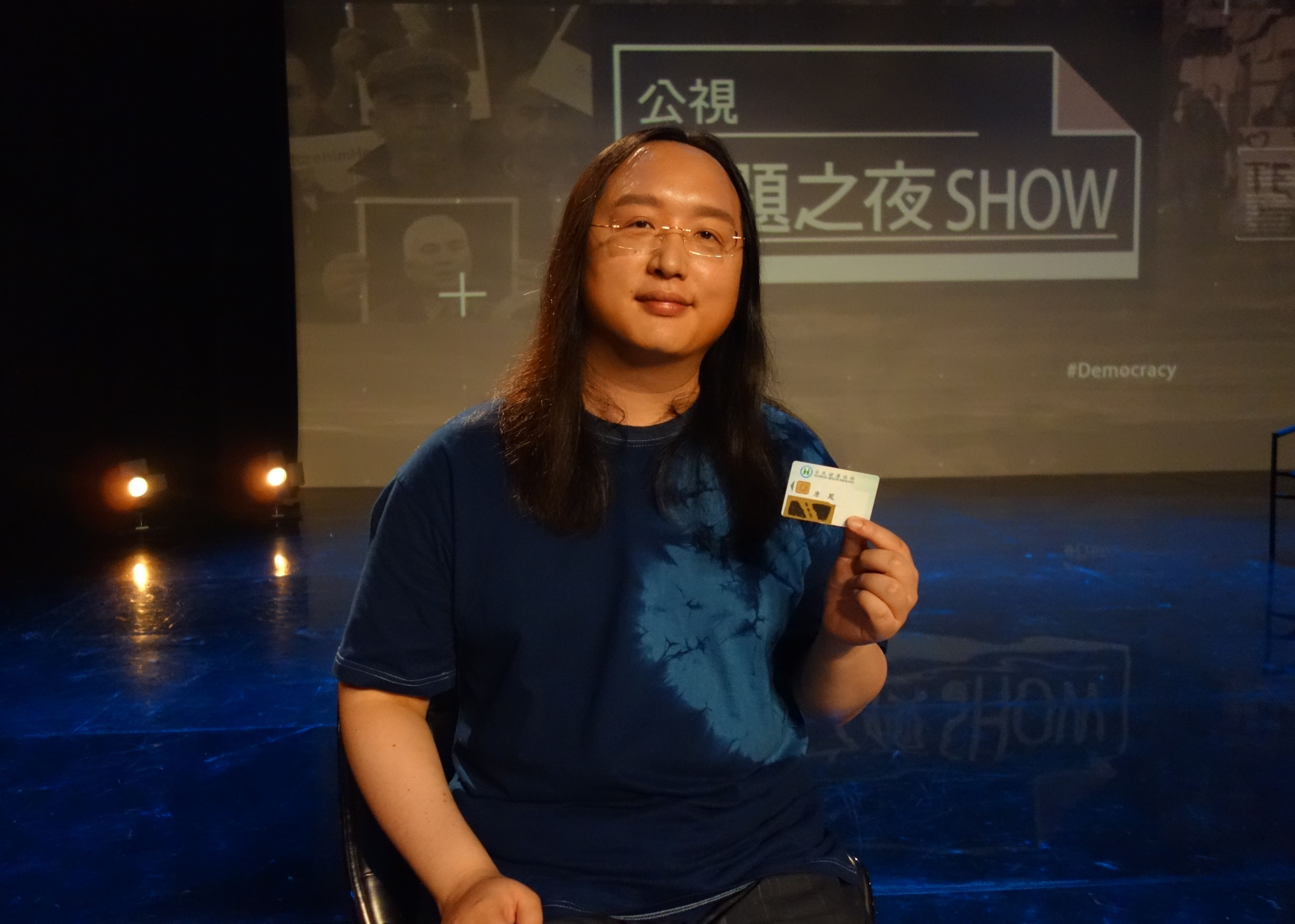 行政院數位政委唐鳳秀出自己貼上不透明膠帶的健保卡。（公視提供）