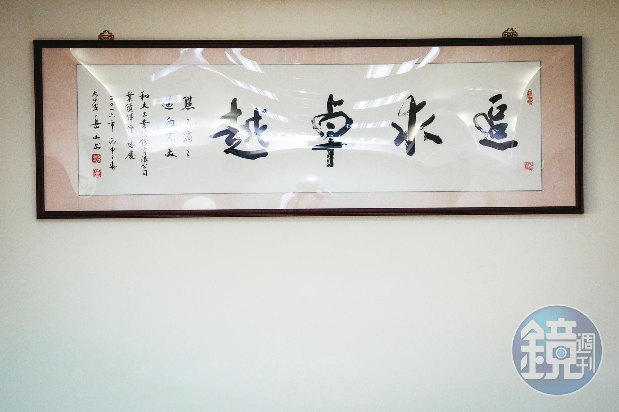 沈國榮在辦公室掛著寫有「追求卓越」的字畫,提醒自己要不斷精進。