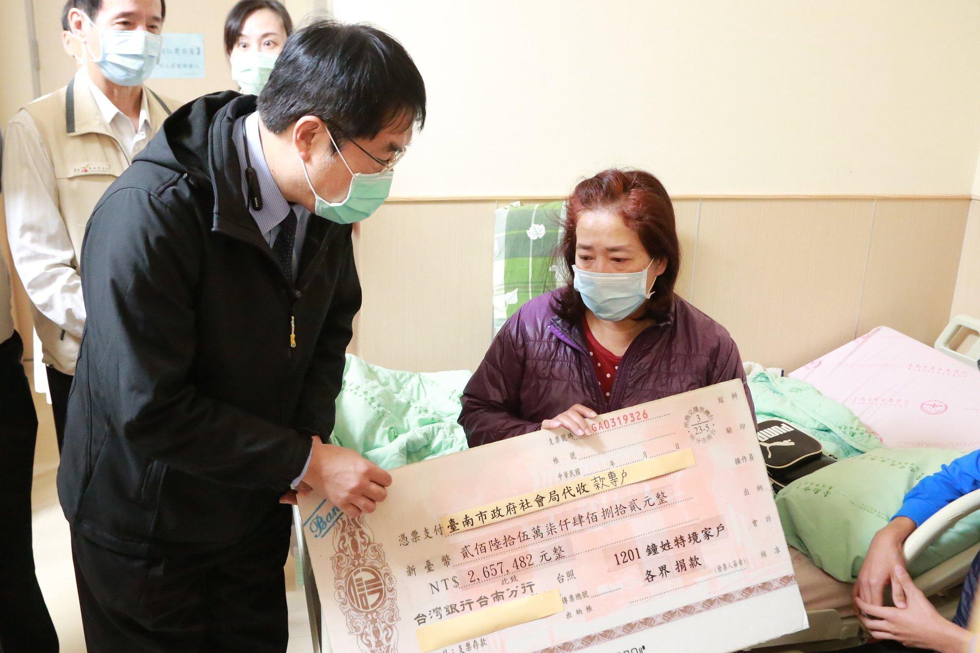 黃偉哲拿支票手板交給鐘姓護理師家屬,遭質疑作秀。(翻攝自黃偉哲臉書)