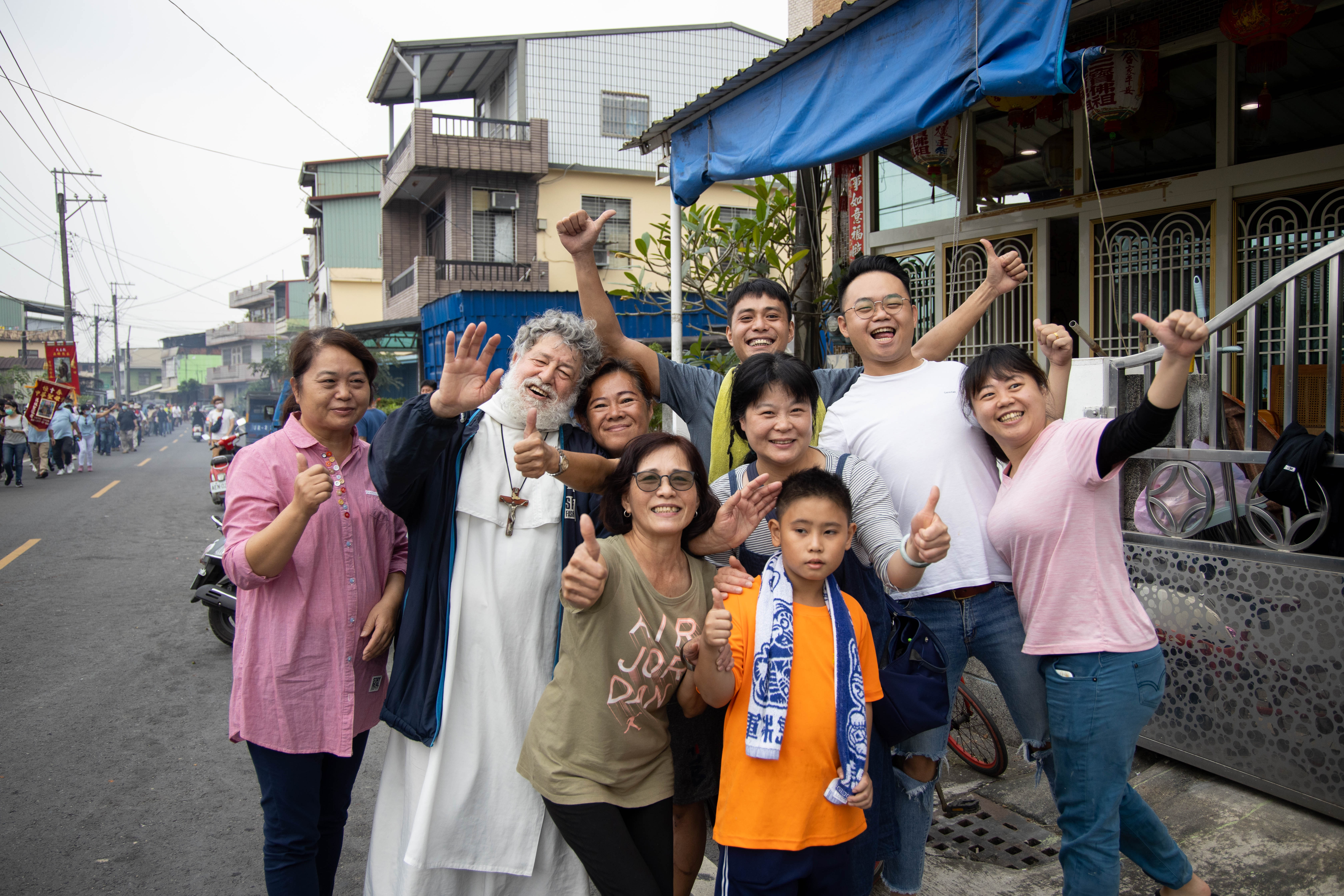 遊行時這位可愛的外國神父（左二）打頭陣，走進街坊跟大家說「祝你平安」「天主保佑」。