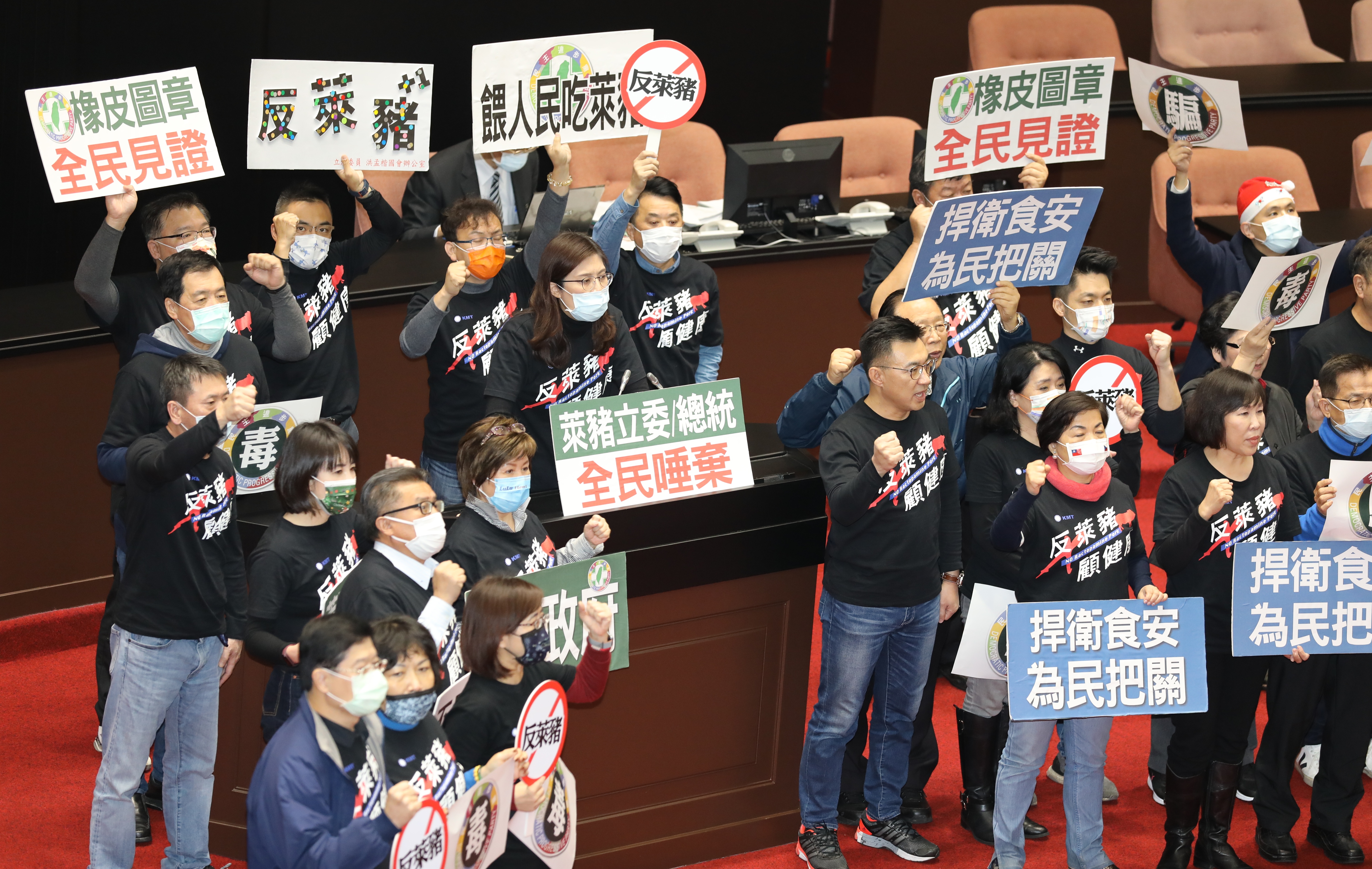 國民黨立委發言時，全體藍委都拿著標語上前助陣。