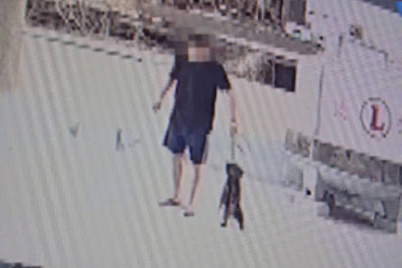 伍男用牽繩把小狗「吊頸」,社區居民看不下他的惡行而報案。(翻攝畫面)