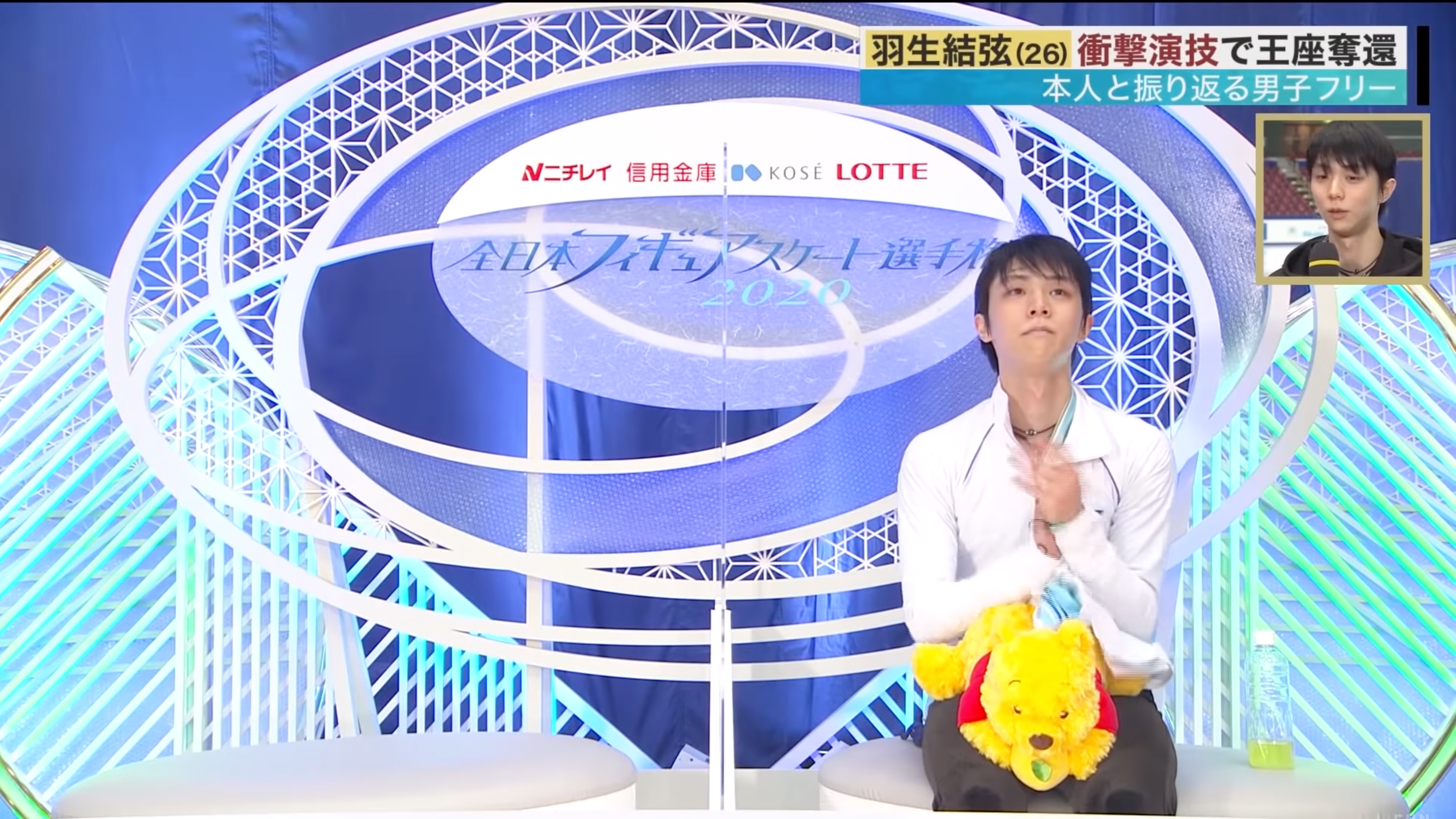 羽生結弦帶著他新款的招牌小熊維尼衛生紙盒等待比賽成績。(翻攝自「FNN」YouTube)