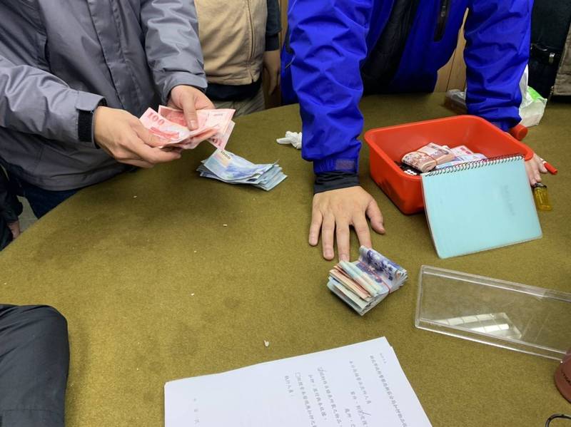 警方清算桌面上的賭資與抽頭金,現場賭資計有16萬元。(林慶祥翻攝)